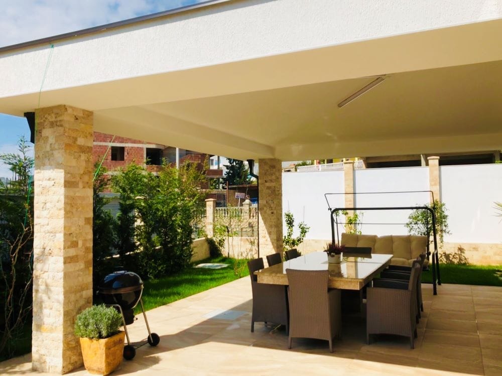 Covered terrace with dining area and grill in a private house, Dobri Vody, Montenegro: modern stone finish.