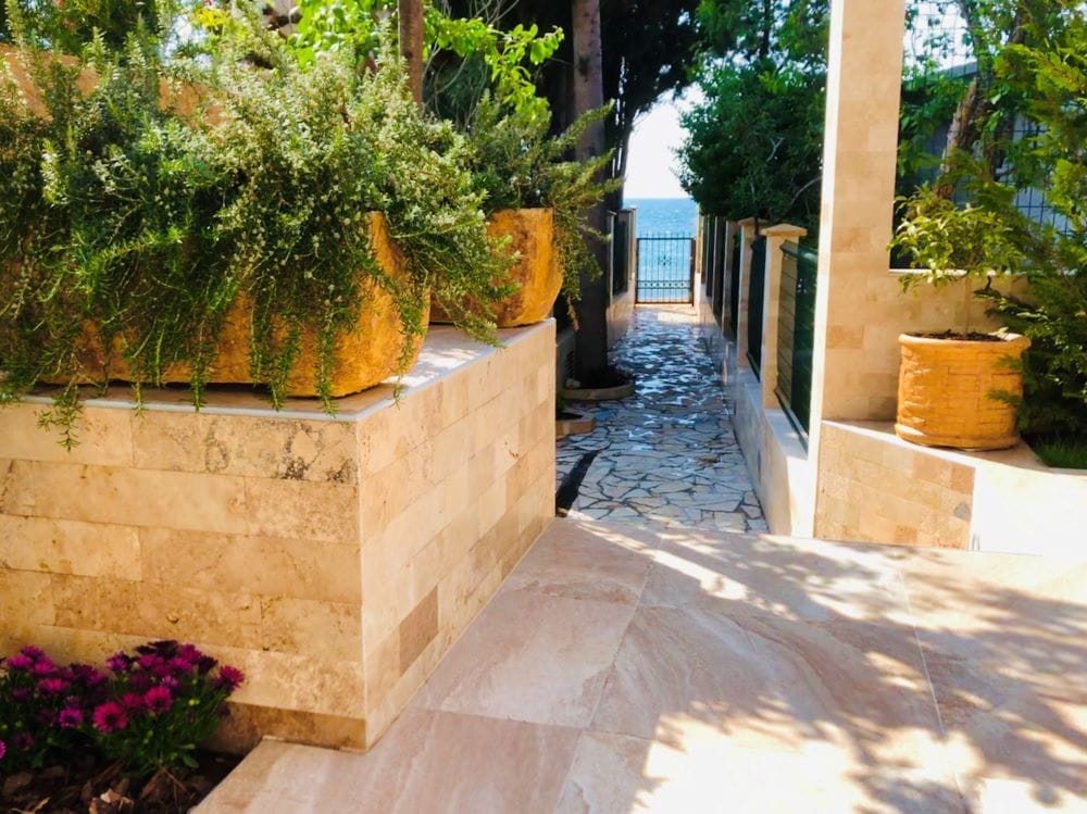 Path to the sea on the private grounds of a house in Dobra Voda, Montenegro: stone finish, landscaping, and sea view.