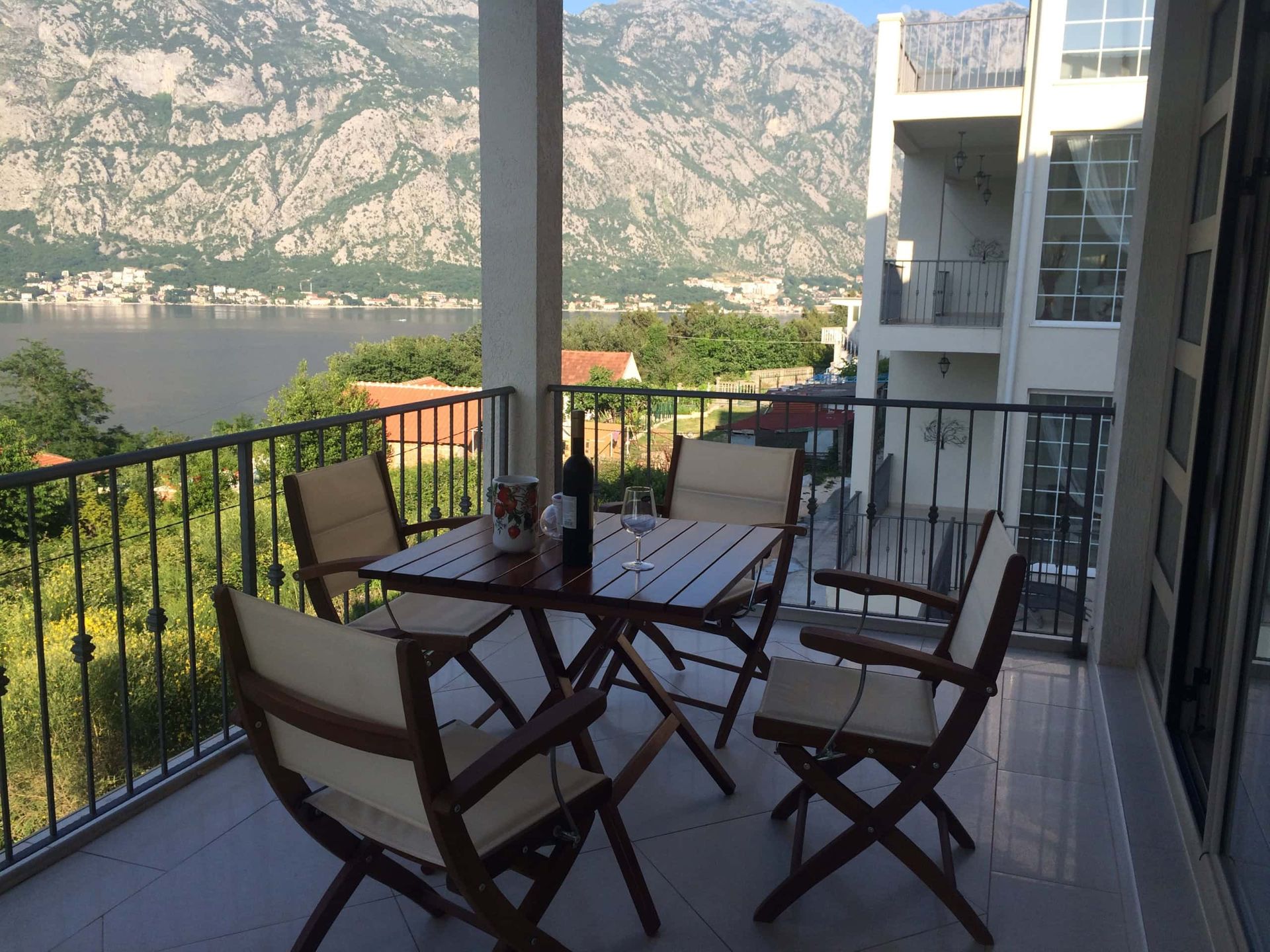 Terrace with furniture and panoramic views of the Bay of Kotor and the mountains in Prčanj, Montenegro.