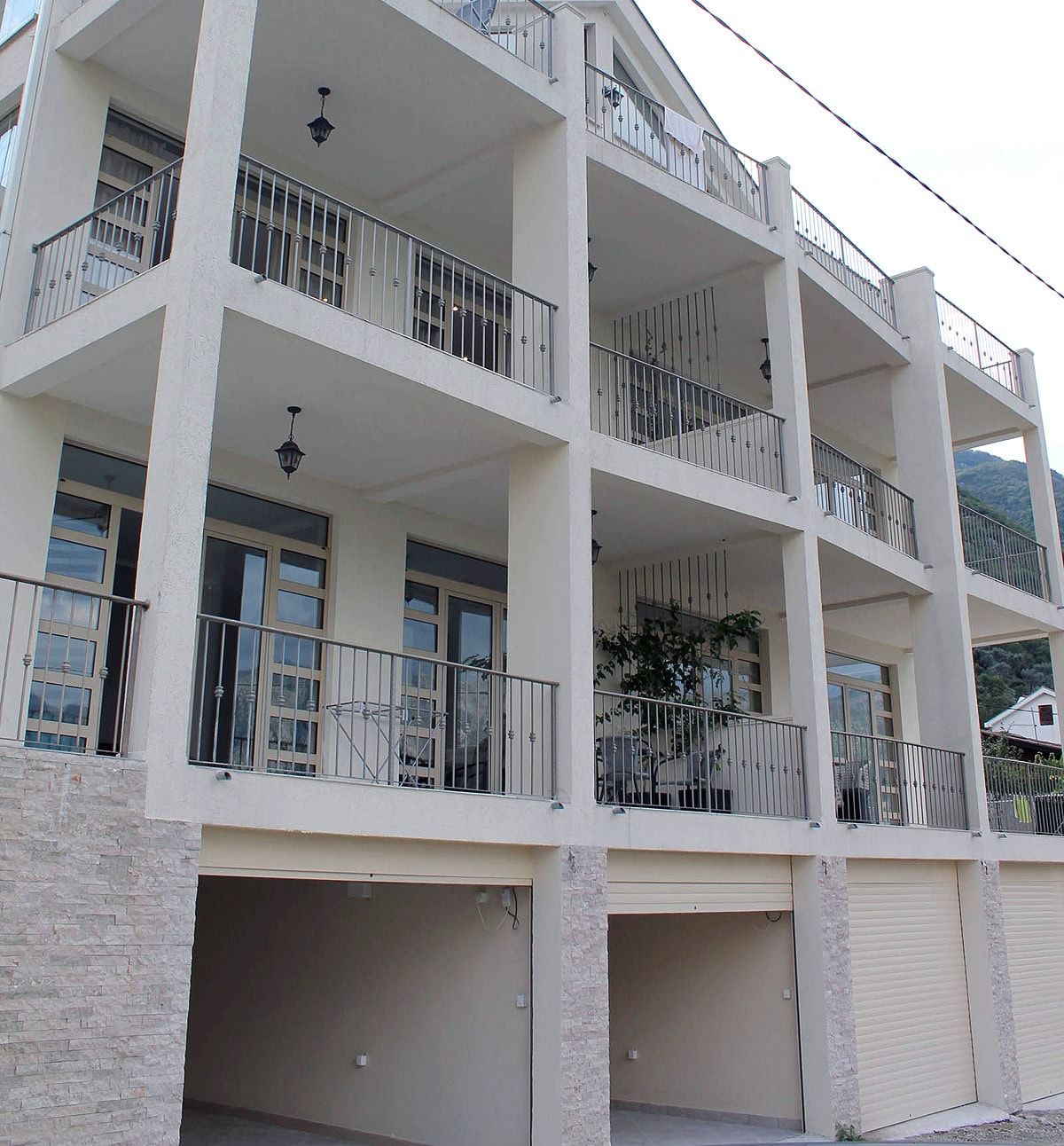 Facade of a modern residential building with balconies and garages in Prčanj, Montenegro: view of an apartment property.
