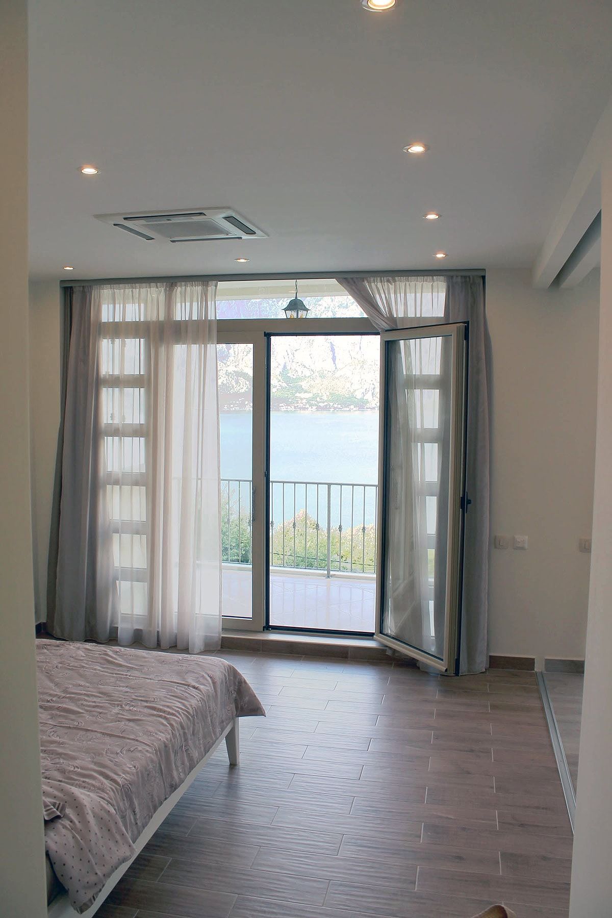 Bedroom in an apartment in Prčanj, Montenegro: panoramic sea and mountain views, bright interior, access to the terrace.