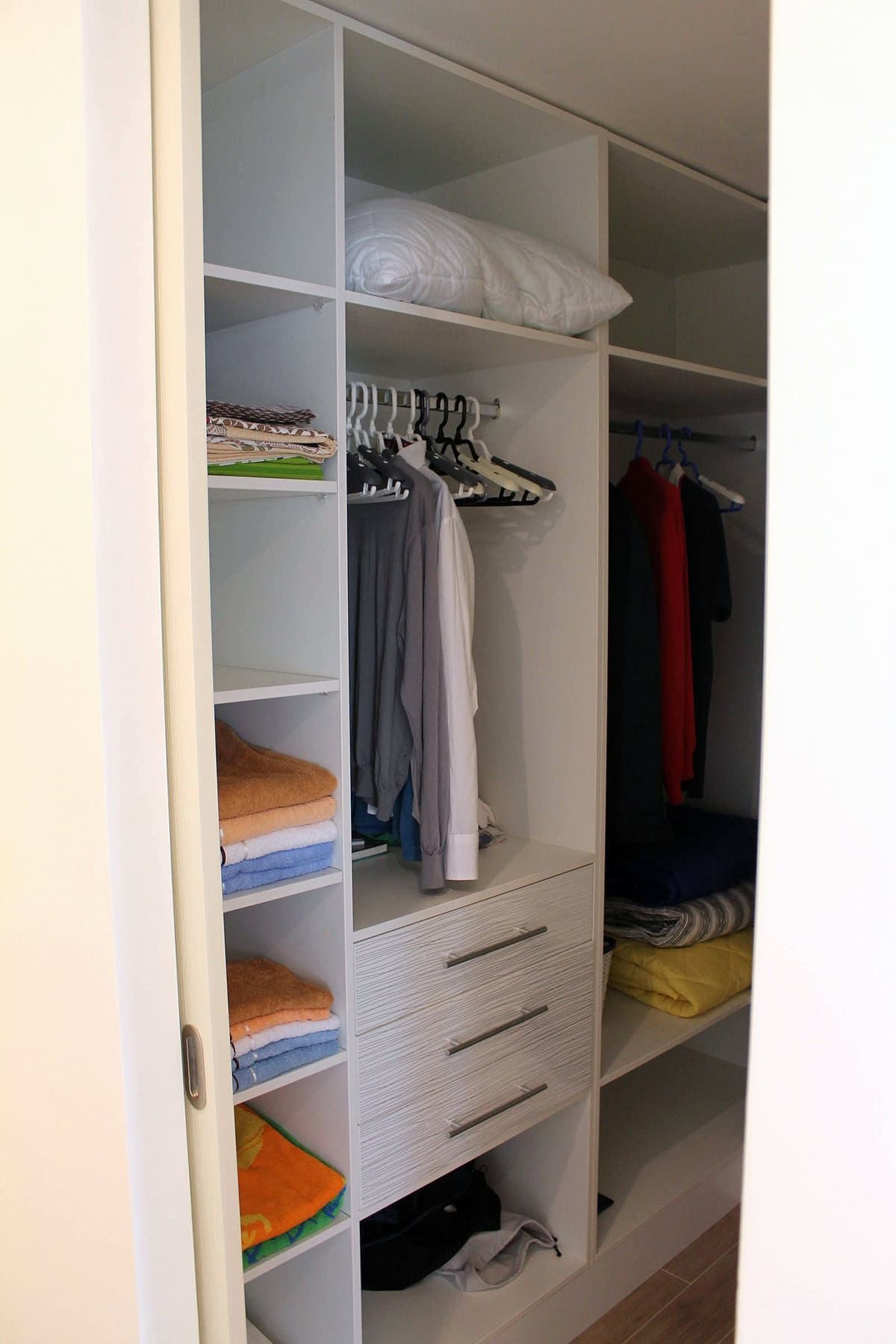 Built-in white wardrobe with shelves and drawers in the apartment, Prčanj, Montenegro.