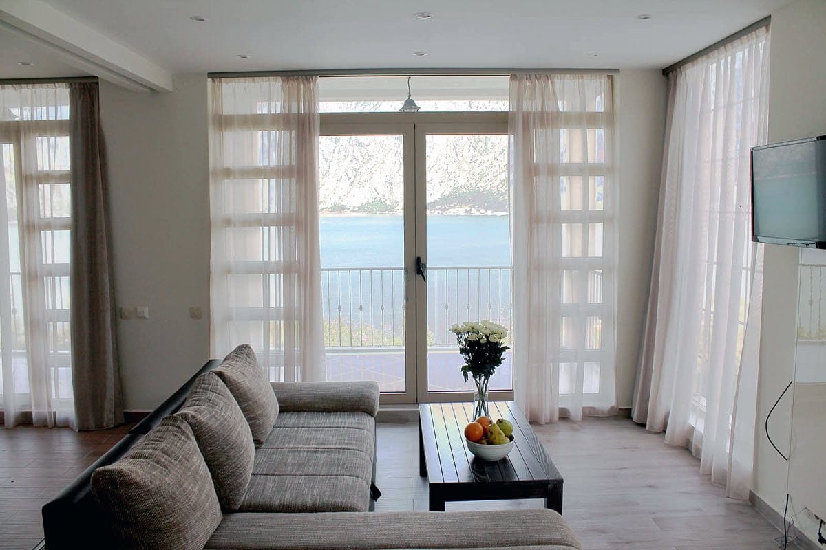 Living room in an apartment in Prčanj, Montenegro: modern furniture, bright interior, and panoramic views of the Bay of Kotor.