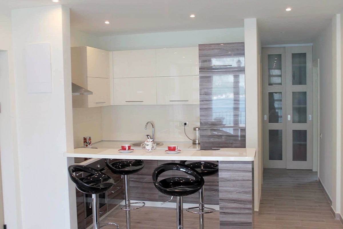 Modern kitchen with a breakfast bar and glossy cabinets in an apartment, Prčanj, Montenegro.