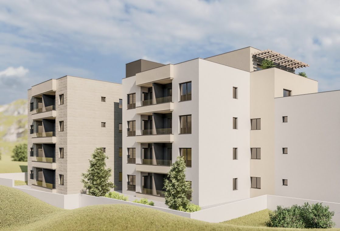Modern residential complex in Budva, Montenegro: facade of a new apartment building with balconies and a rooftop terrace.