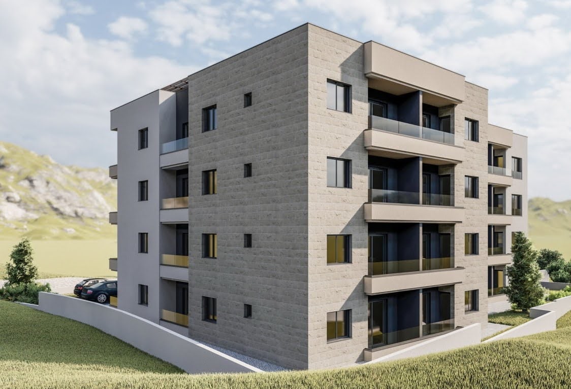 Modern residential complex in Budva, Montenegro: building facade with balconies, panoramic windows, and parking by the building.