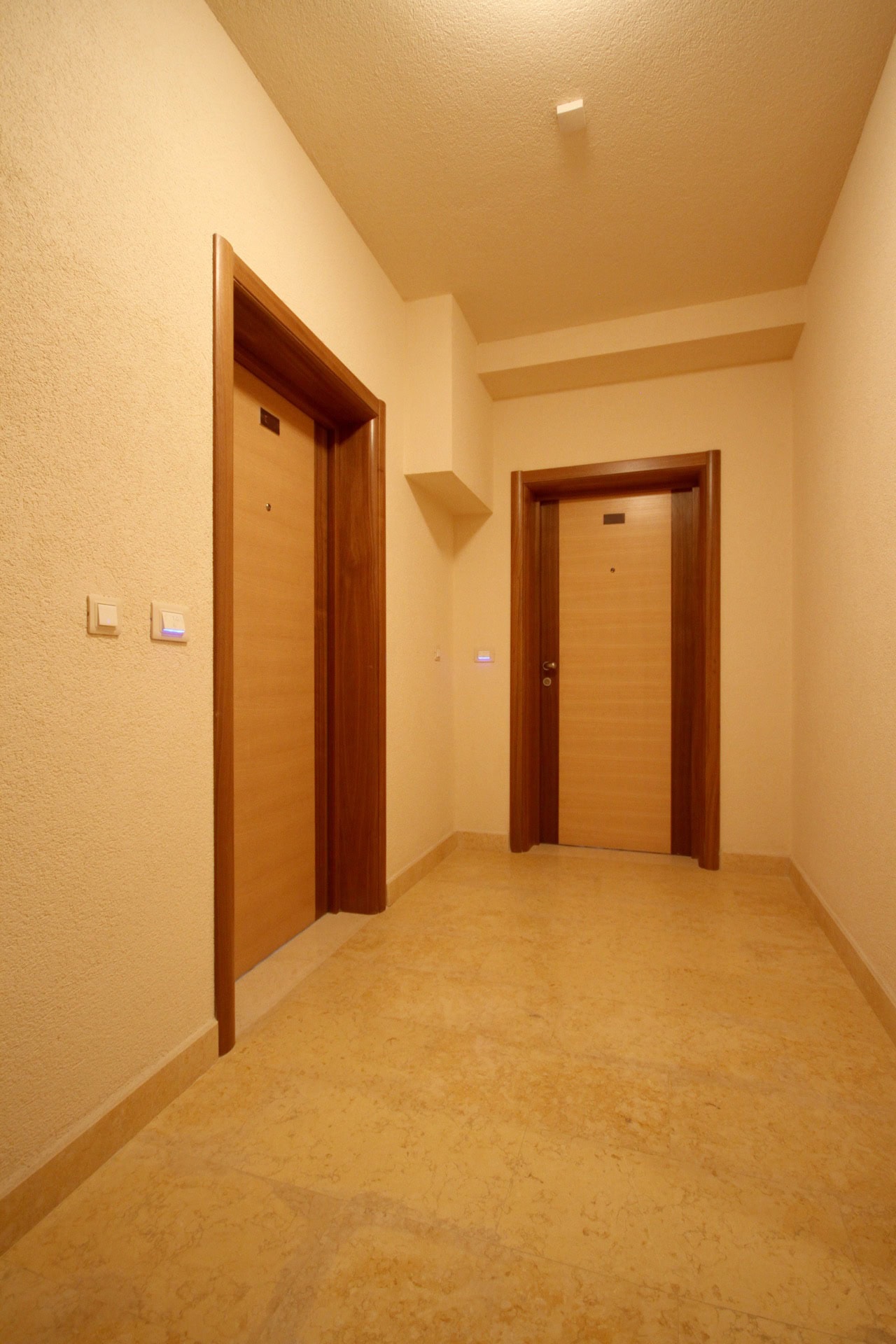 Bright hallway in an apartment in Bečići, Montenegro: quality wall finishes, interior doors, and stone flooring.