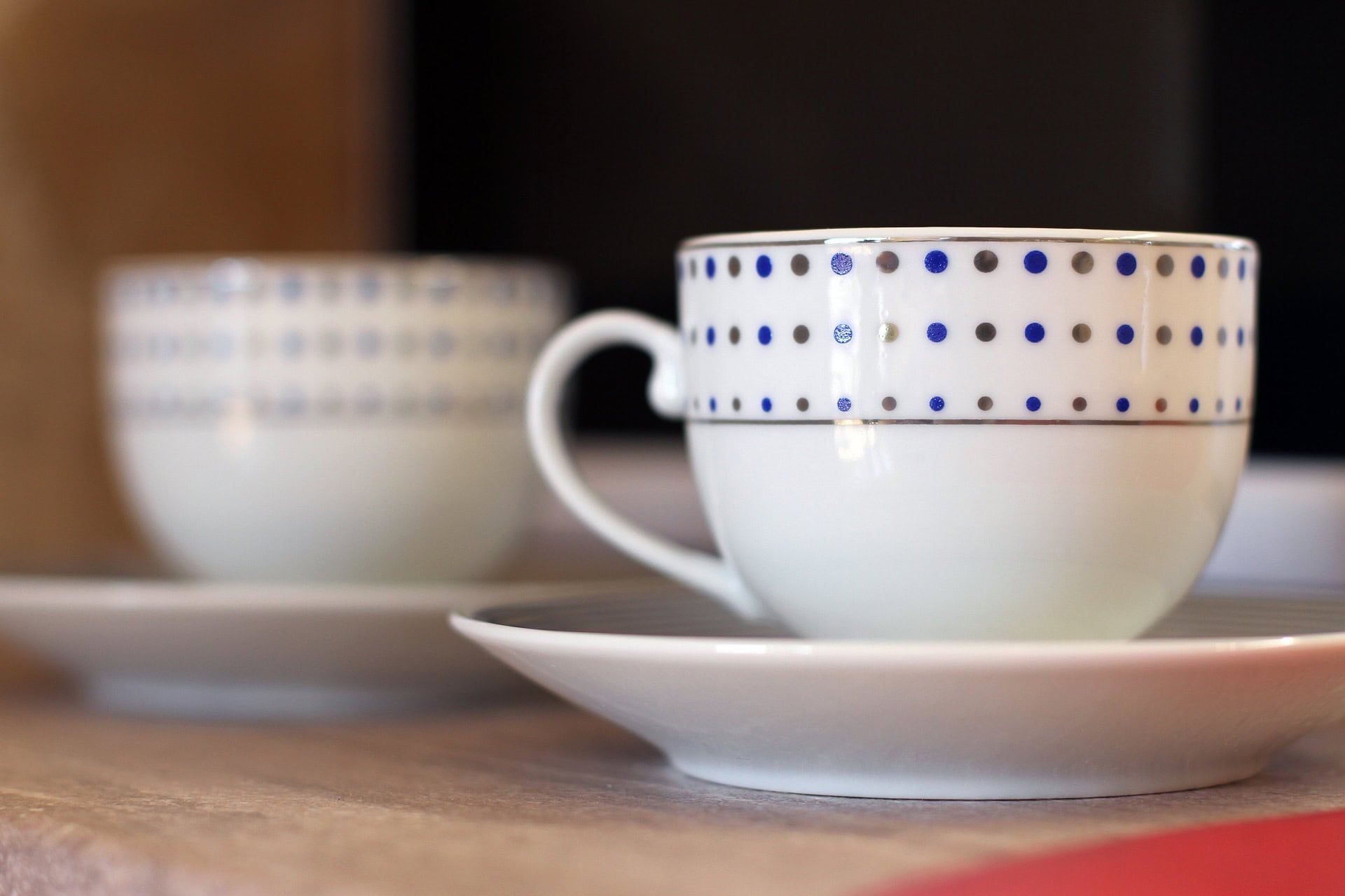 Two polka dot porcelain cups on a wooden table in an apartment interior in Bečići, Montenegro.