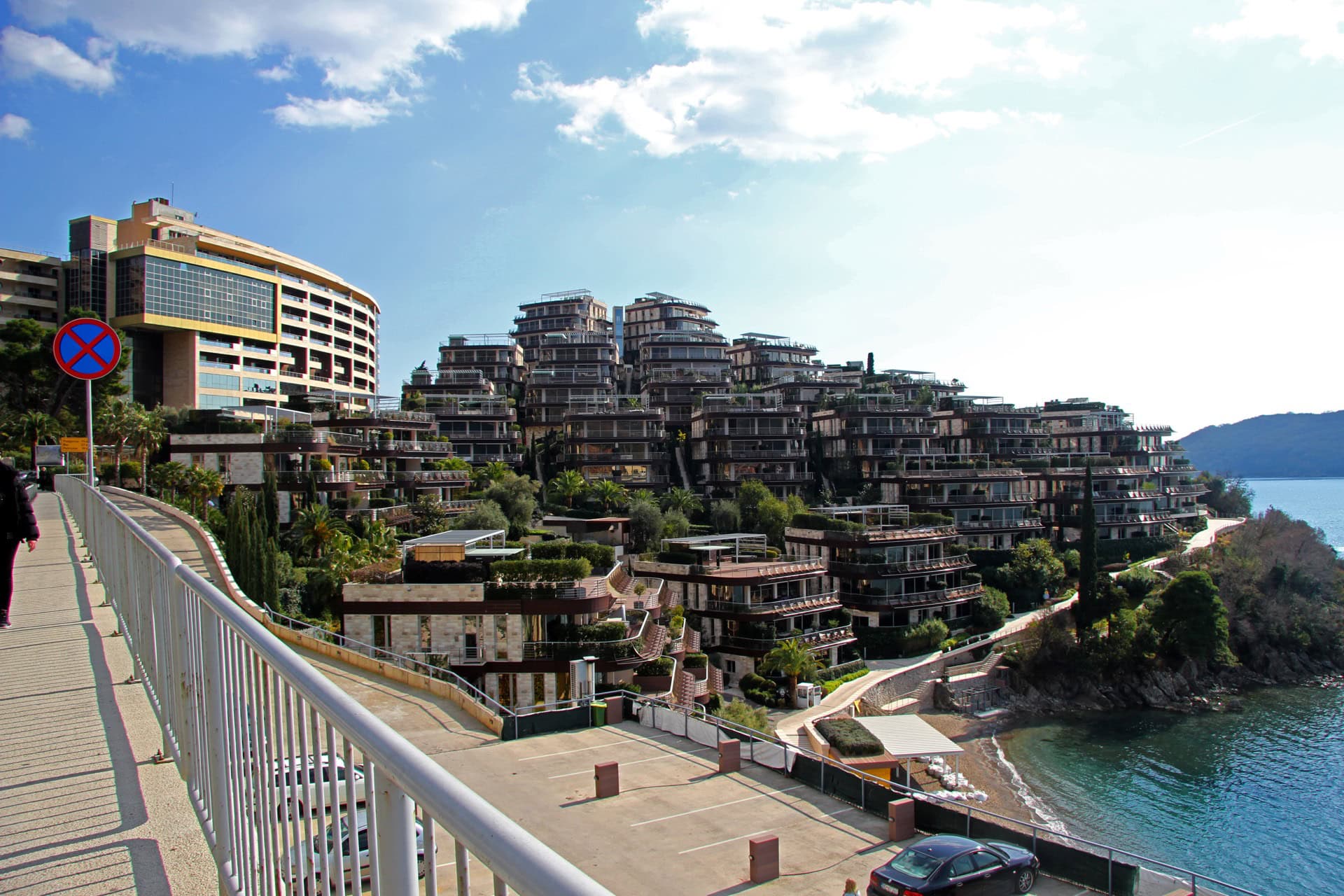 Modern residential complex with terraces by the sea in Bečići, Montenegro: panoramic view of luxury apartments and the beach.
