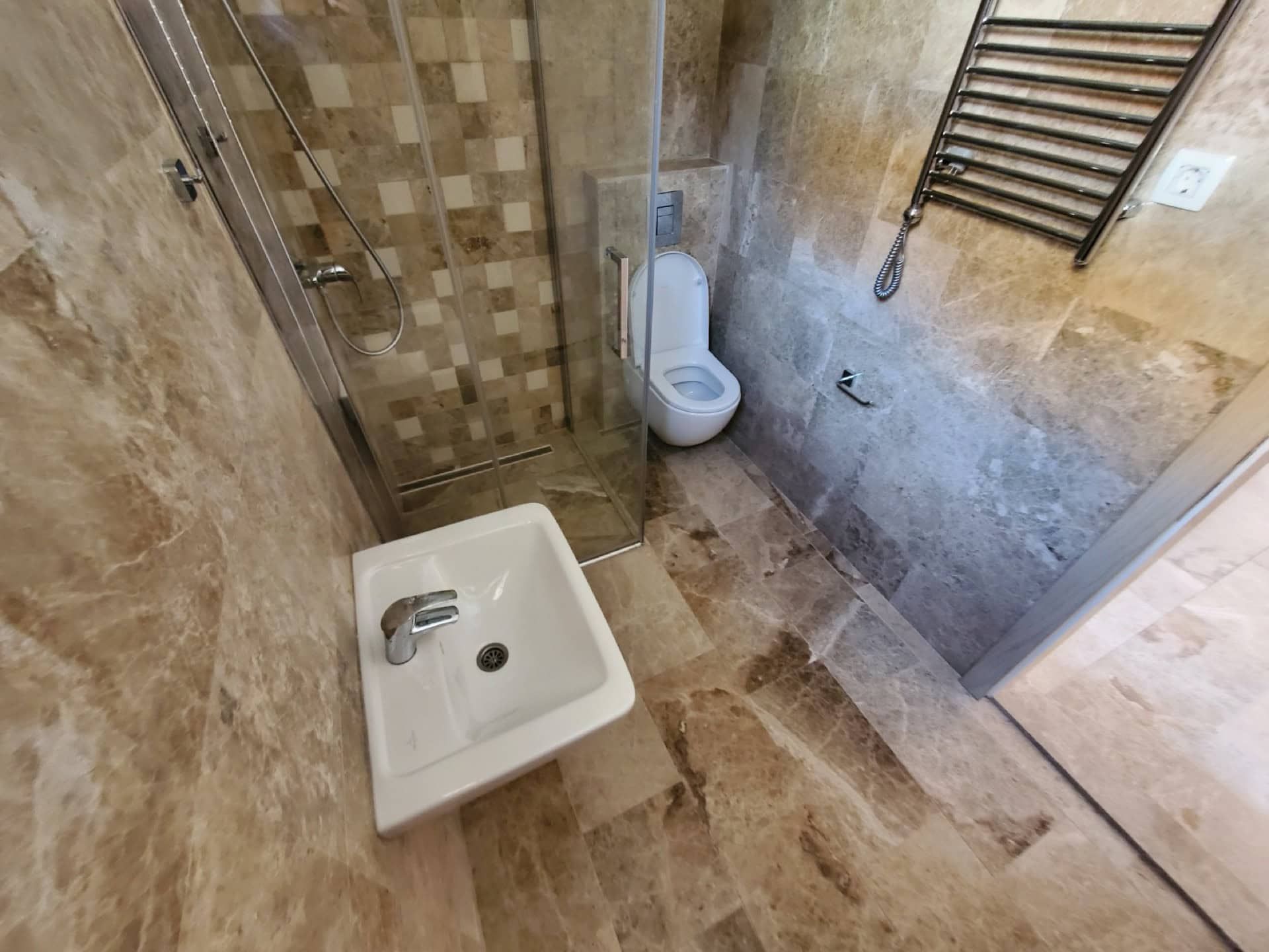 Modern bathroom in a penthouse in Pržno, Montenegro: shower cabin, fixtures, and natural stone finishes.