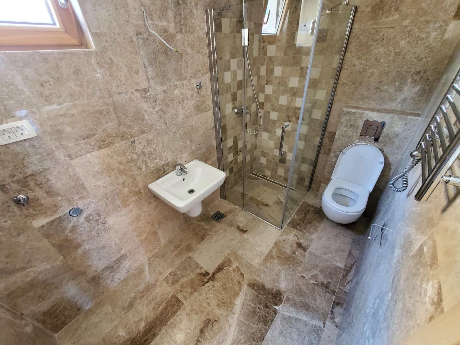 Modern bathroom with a shower cabin and natural stone finishes in a penthouse, Pržno, Montenegro.