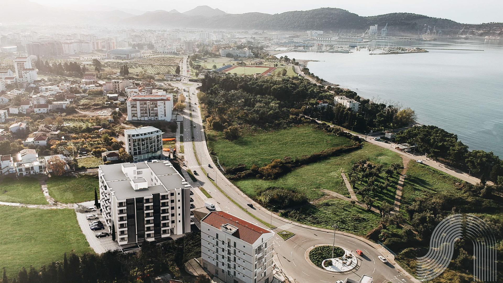 Aerial panoramic view of a residential complex in Bar, Montenegro, with the seaside and city infrastructure.