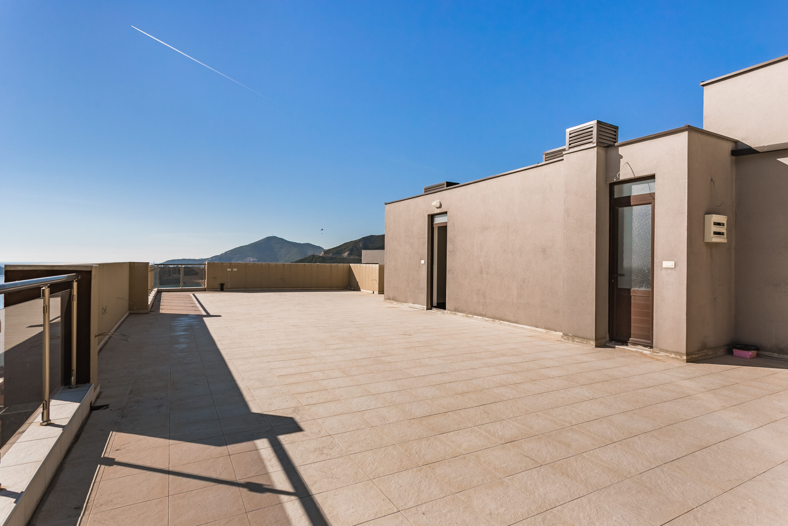 Spacious open penthouse terrace in Rafailovici, Montenegro, with panoramic mountain and sea views.