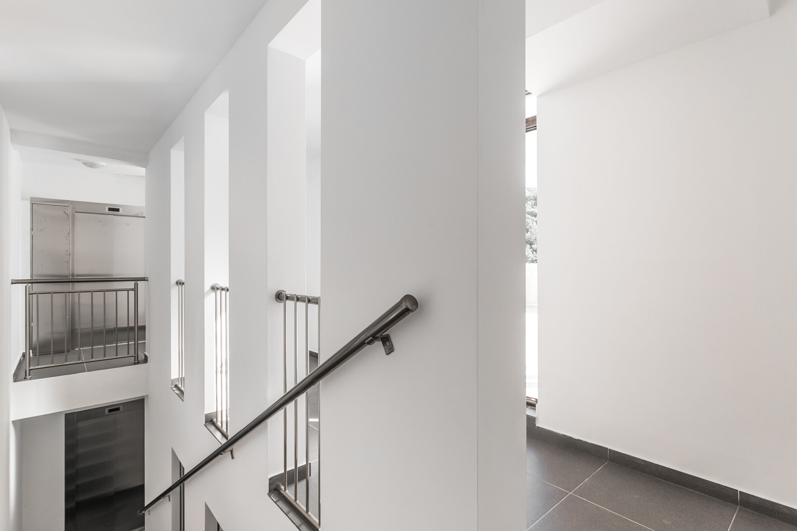 Modern staircase with metal railings in a residential complex, Rafailovici, Budva Riviera, Montenegro.