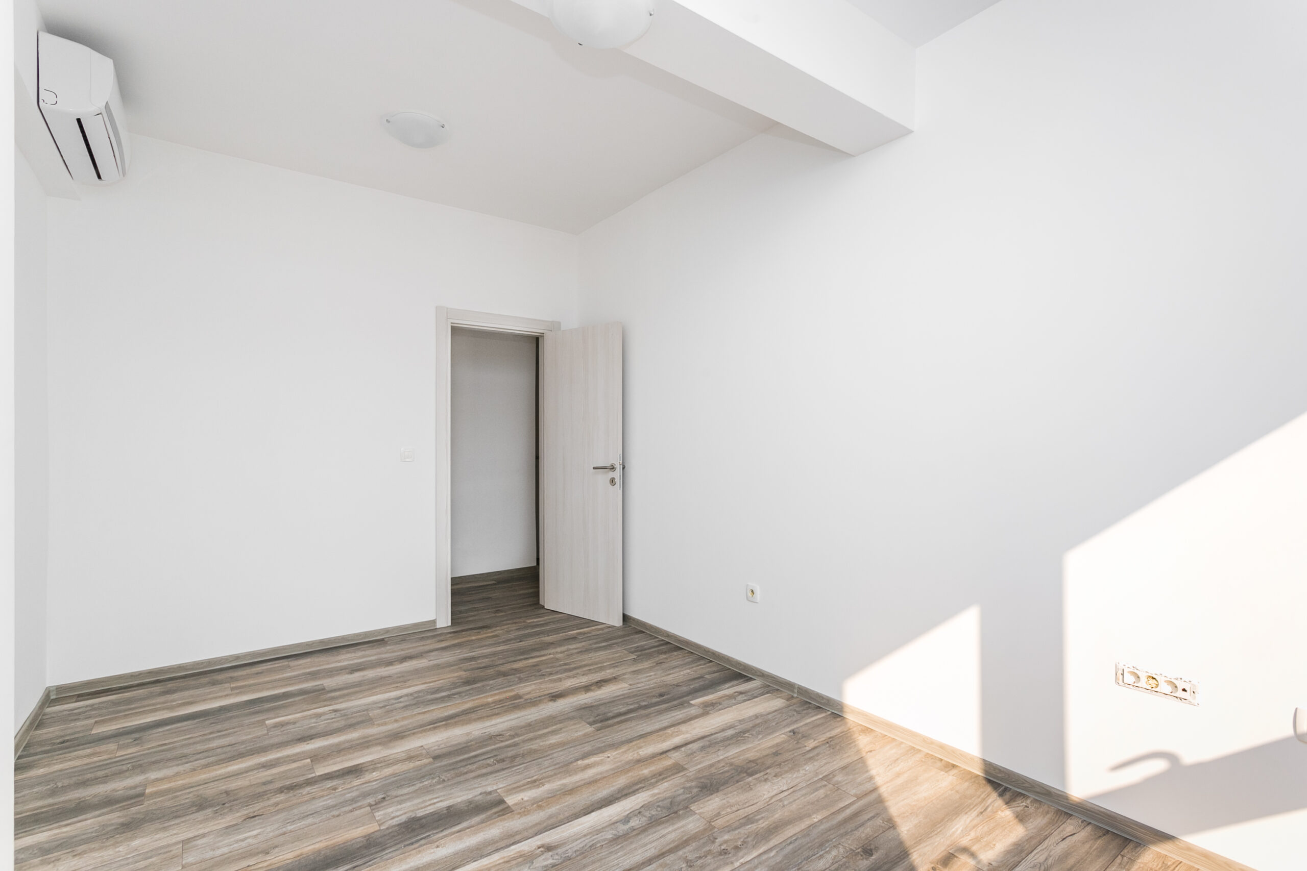 Bright empty living room with laminate flooring and air conditioning in a penthouse, Rafailovici, Budva Riviera, Montenegro.