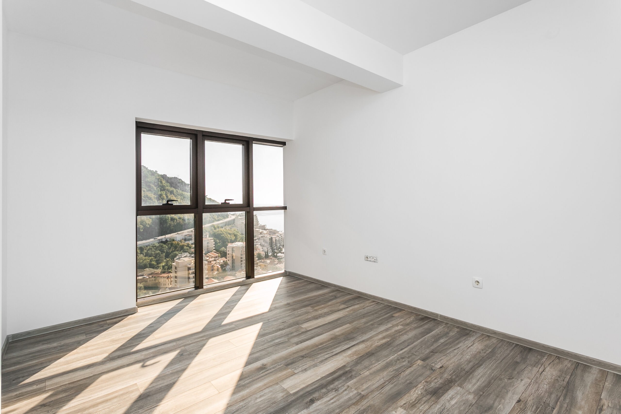 Bright living room with a panoramic window and sea view in a penthouse, Rafailovići, Budva Riviera, Montenegro.