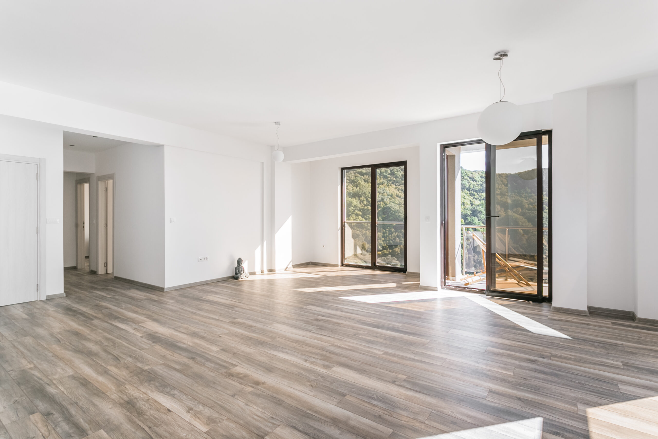 Bright living room in a penthouse, Rafailovici, Montenegro: panoramic windows, mountain view, and access to the terrace.