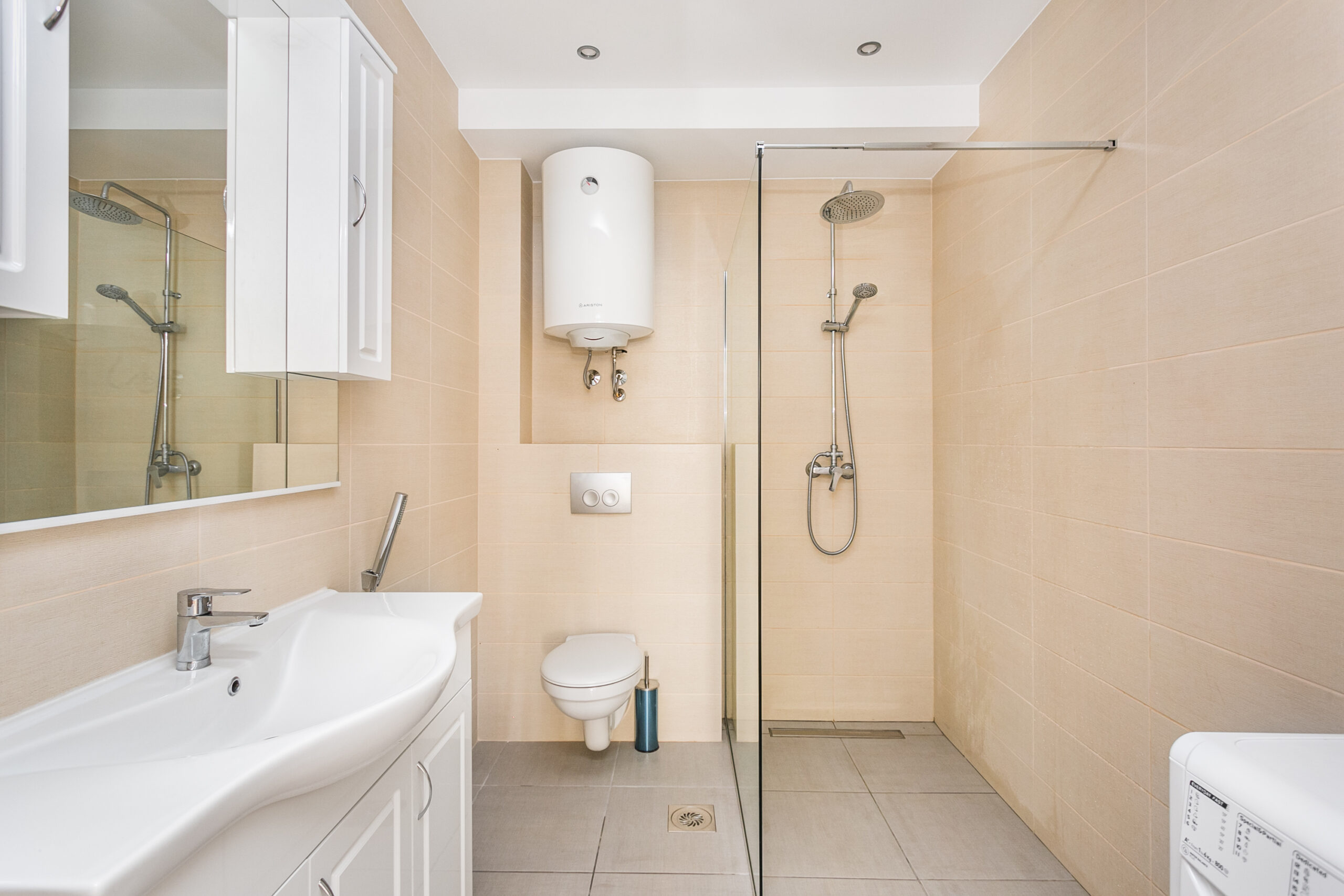 Modern bathroom in a penthouse, Rafailovici, Montenegro: shower cabin, plumbing fixtures, and white furniture.