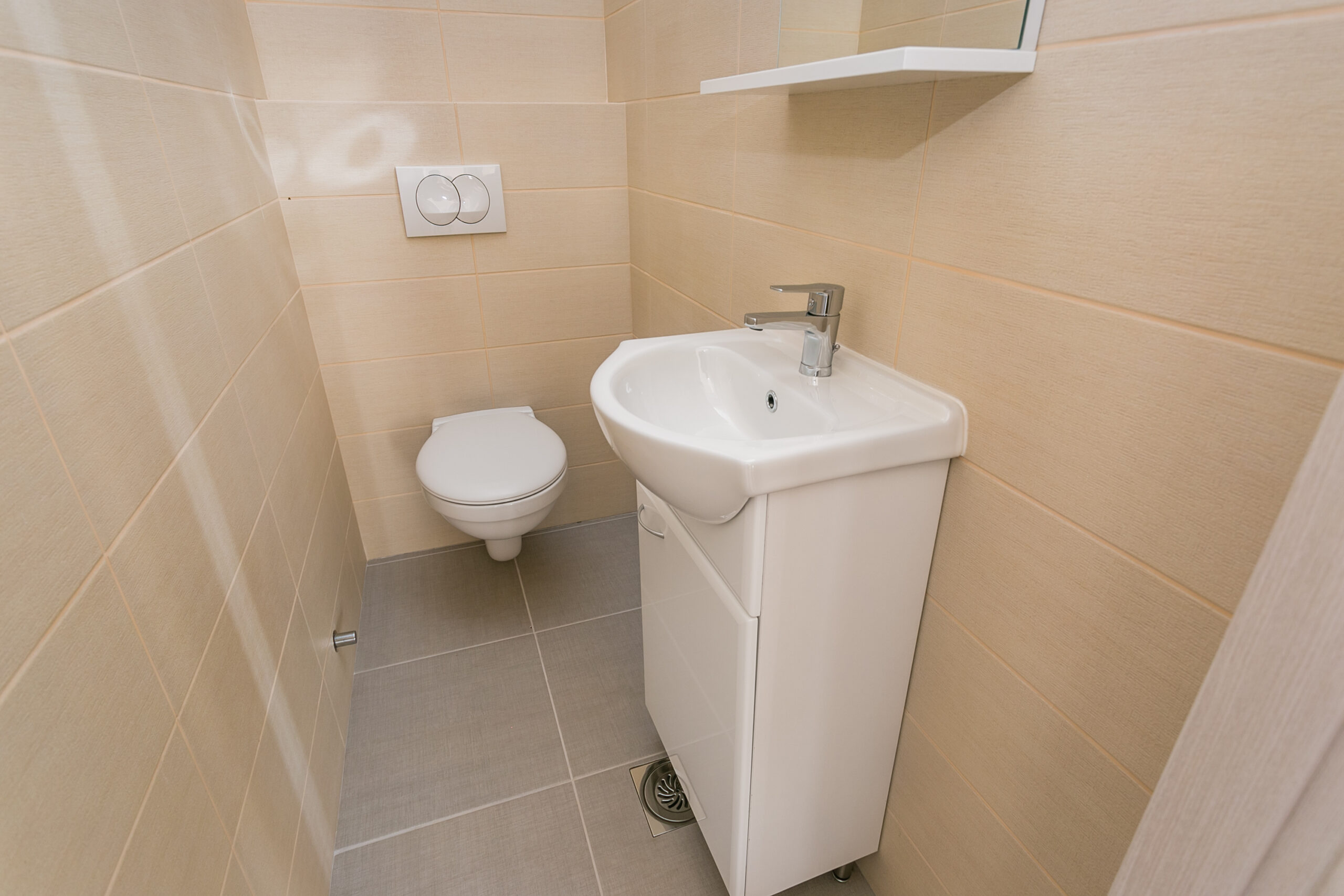 Modern bathroom with white fixtures and beige tiles in a penthouse, Rafailovici, Montenegro.