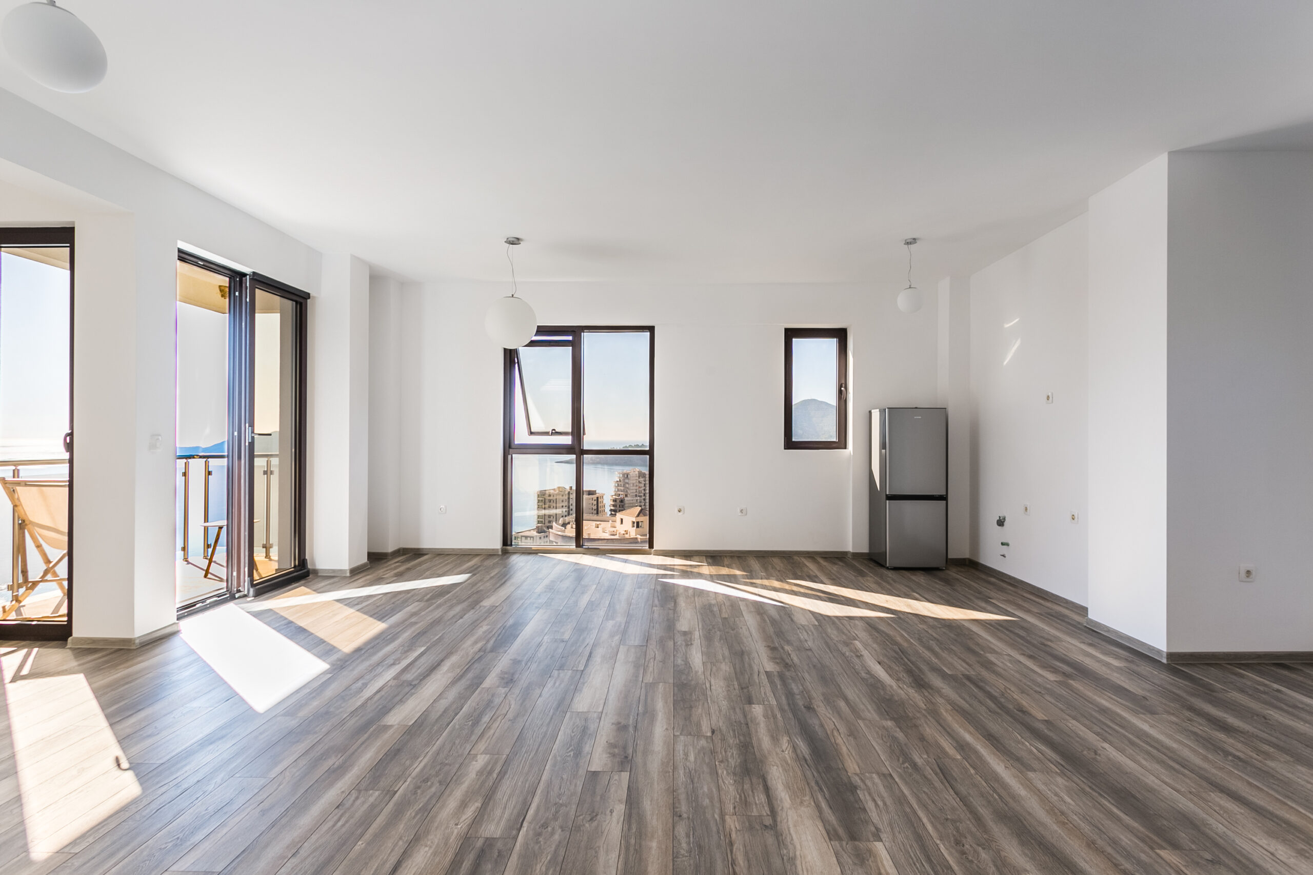 Bright living room in a penthouse in Rafailovici, Montenegro, with panoramic sea views and access to the balcony.