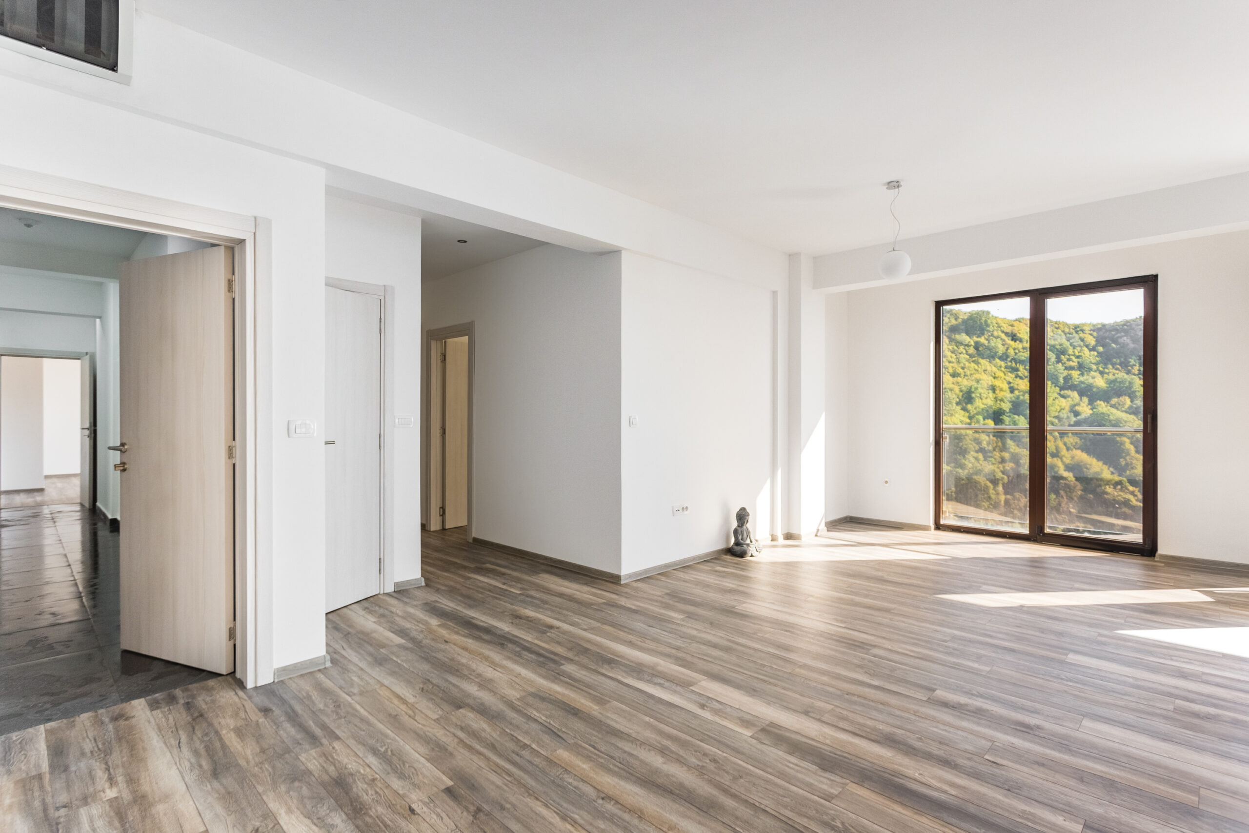 Bright living room in a penthouse, Rafailovici, Montenegro: panoramic windows with mountain views, laminate flooring, and modern design.