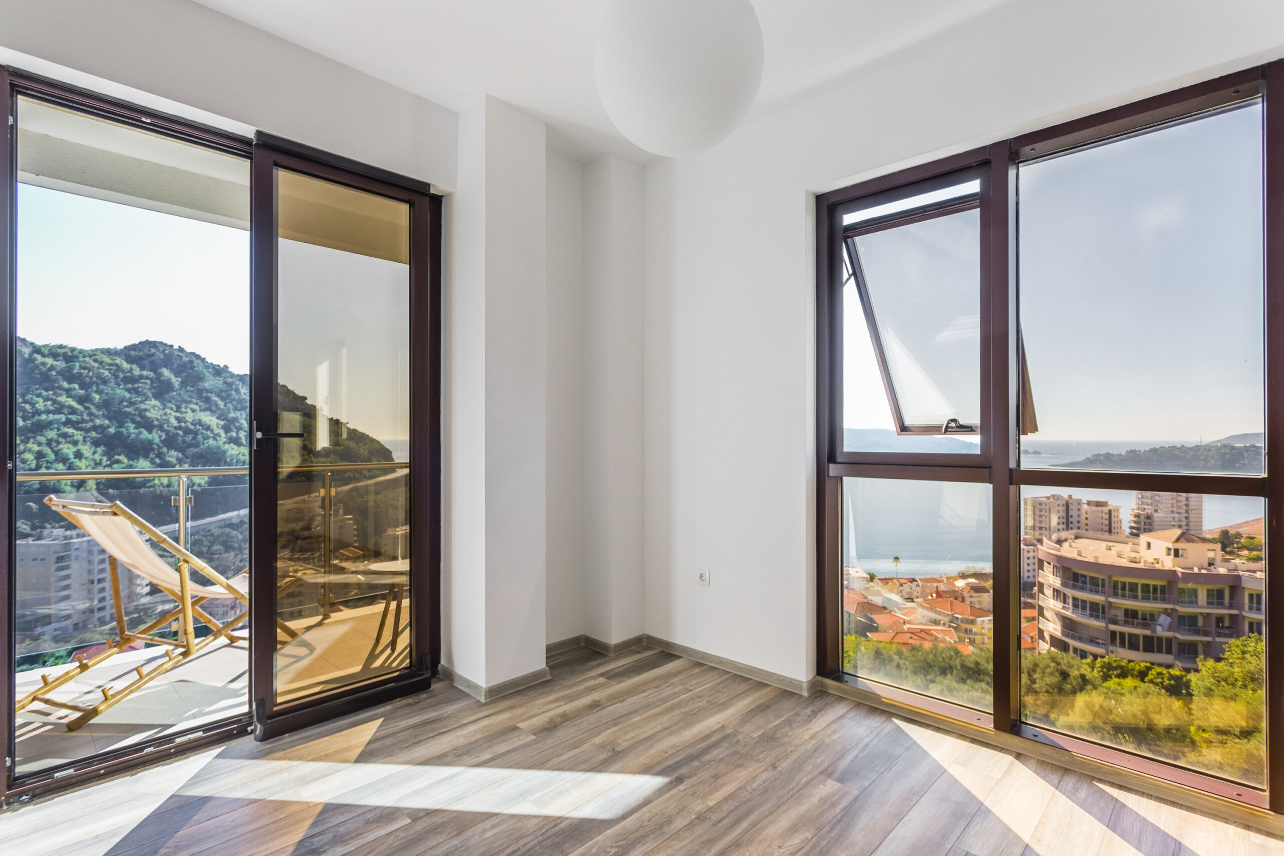 Bright living room with panoramic windows and sea view in a penthouse, Rafailovici, Budva Riviera, Montenegro.