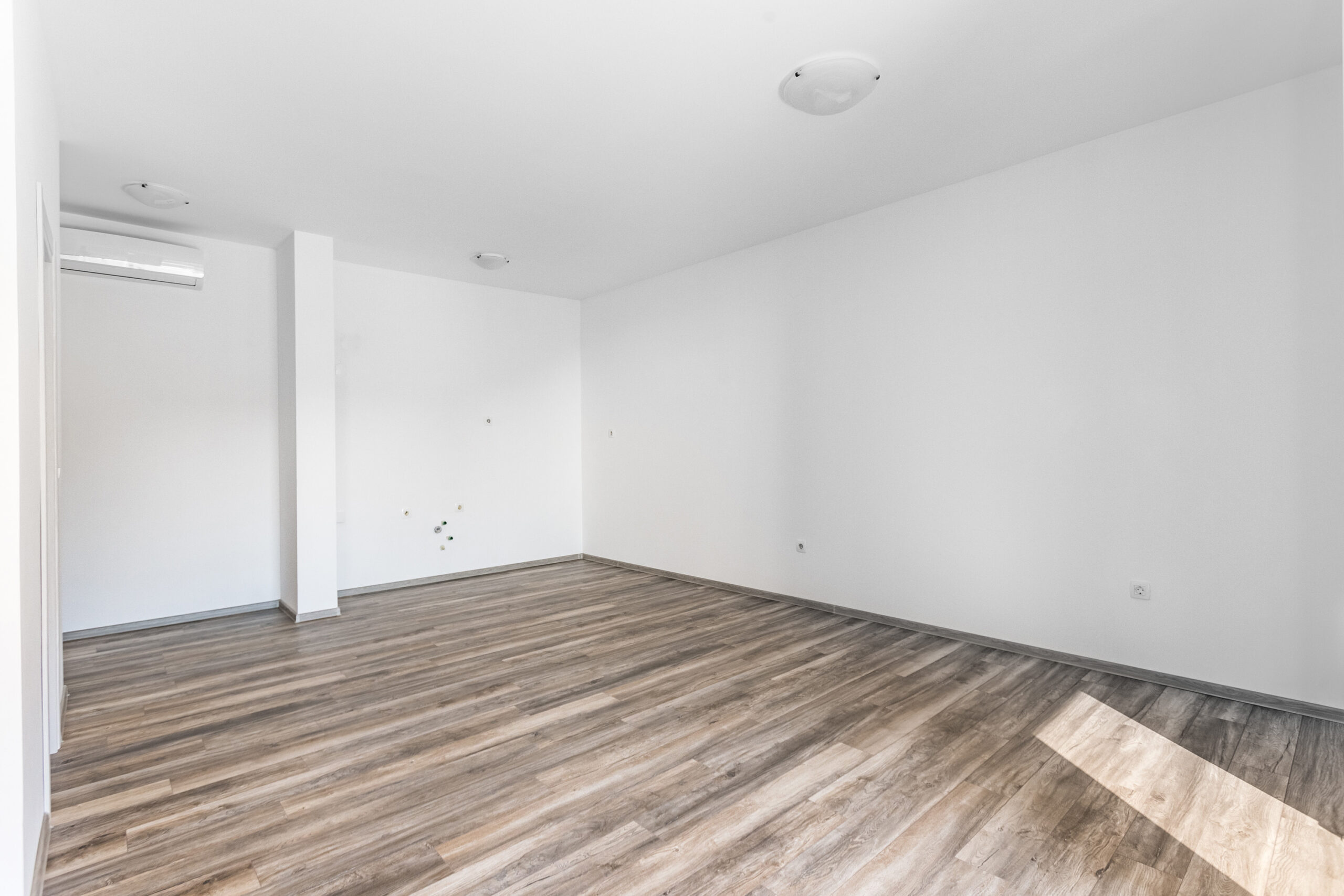 Bright empty living room with laminate flooring and air conditioning in a penthouse, Rafailovici, Budva Riviera, Montenegro.