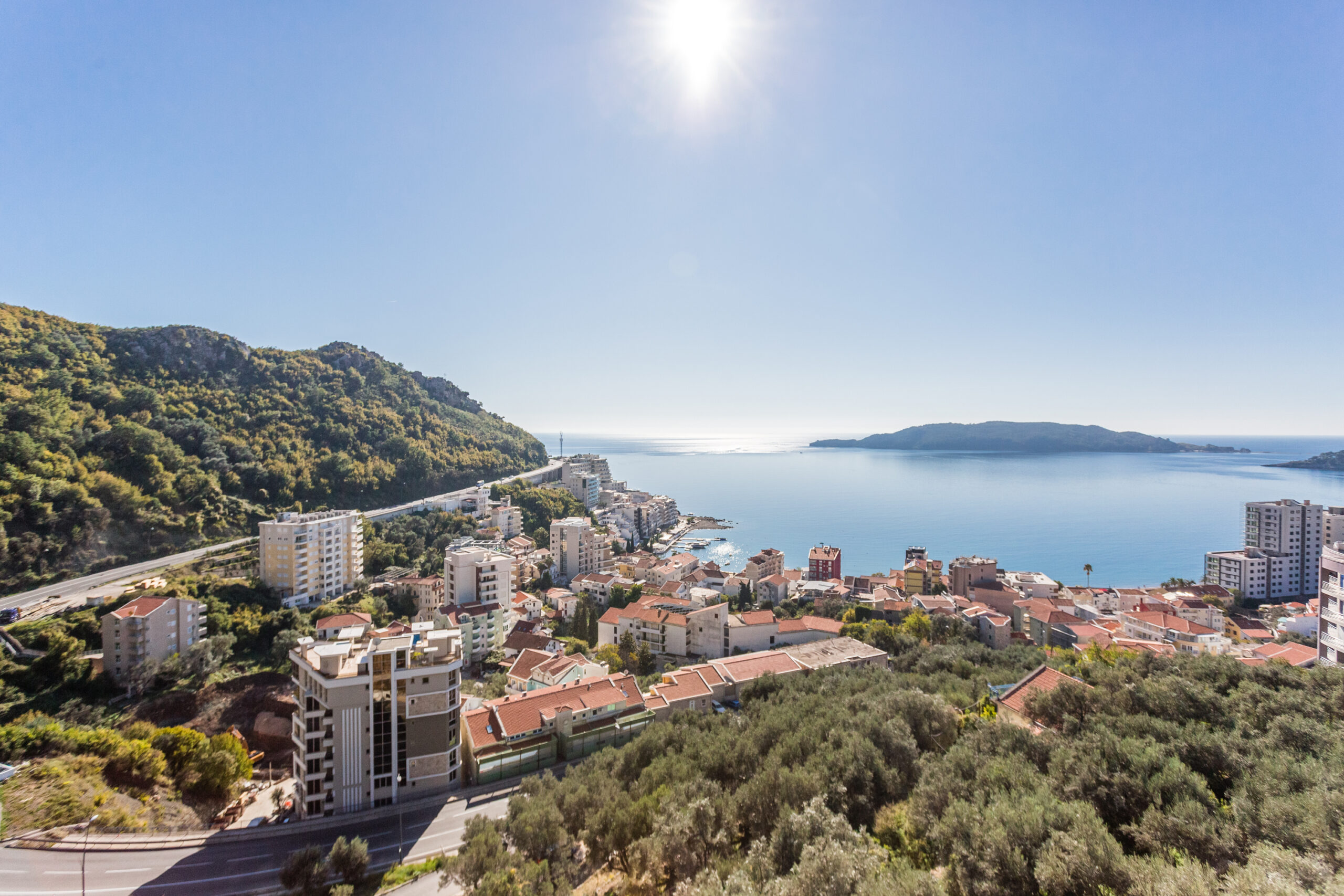 Panoramic view of the sea and the town of Rafailovici, Budva Riviera, Montenegro, from the penthouse terrace surrounded by mountains.