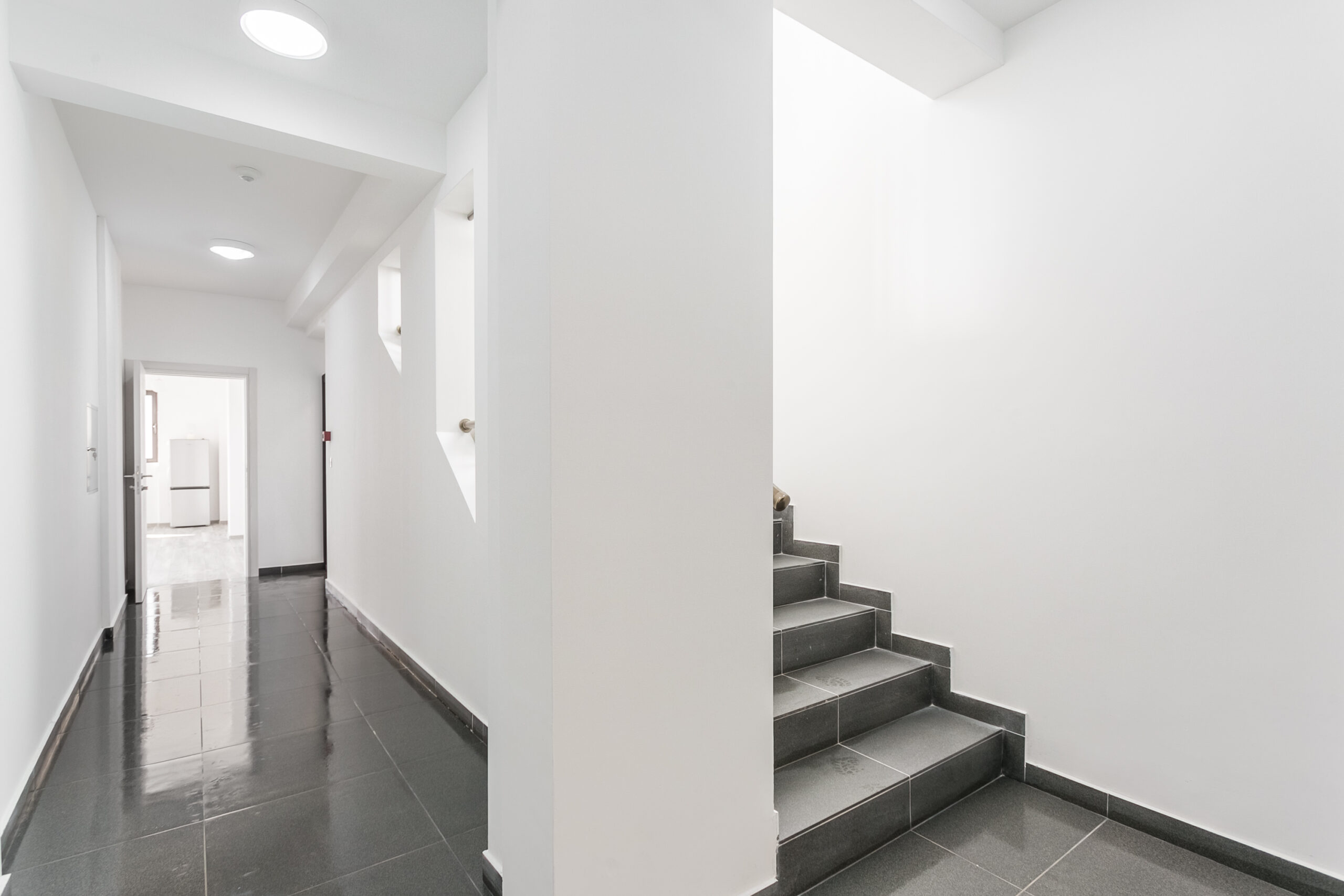 Modern bright hallway with gray tile and staircase in a penthouse, Rafailovici, Budva Riviera, Montenegro.