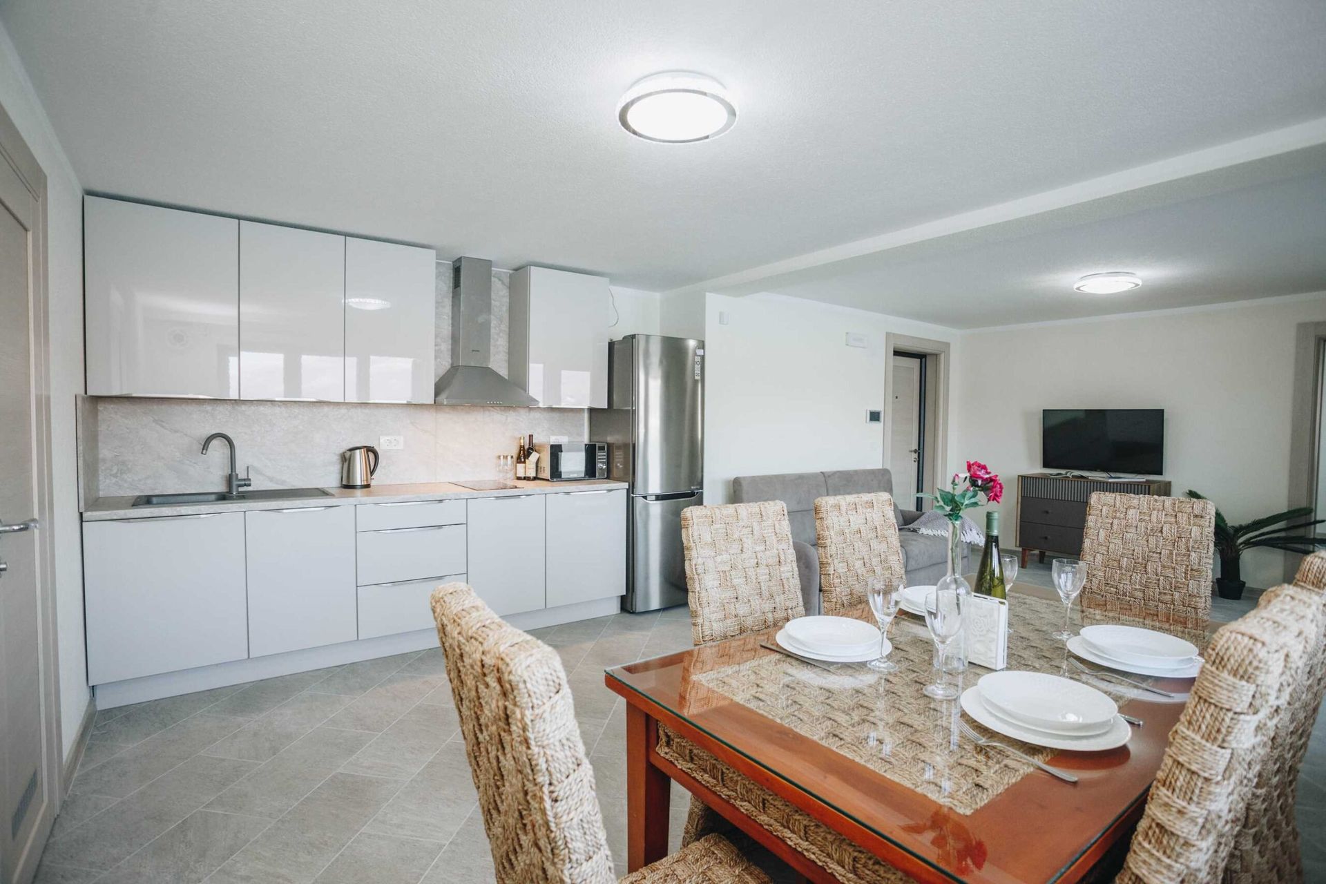 Modern kitchen-living room with dining area in a villa in Krašići, Montenegro: light furniture and stylish interior.