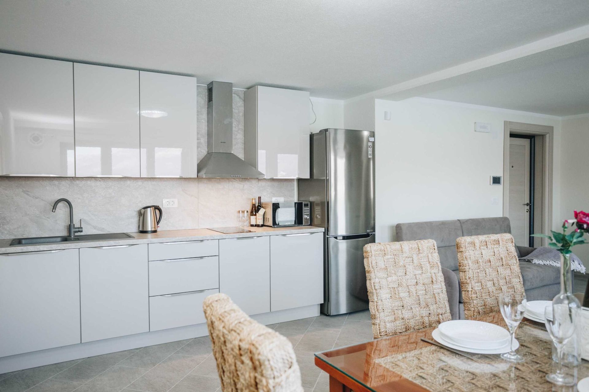 Modern kitchen with light-colored cabinets and a dining area in a villa in Krašići, Montenegro.