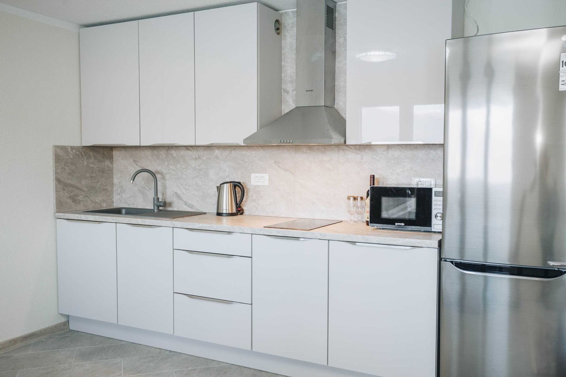 Modern white kitchen with Gorenje appliances in an apartment in a villa in Krašići, Montenegro.