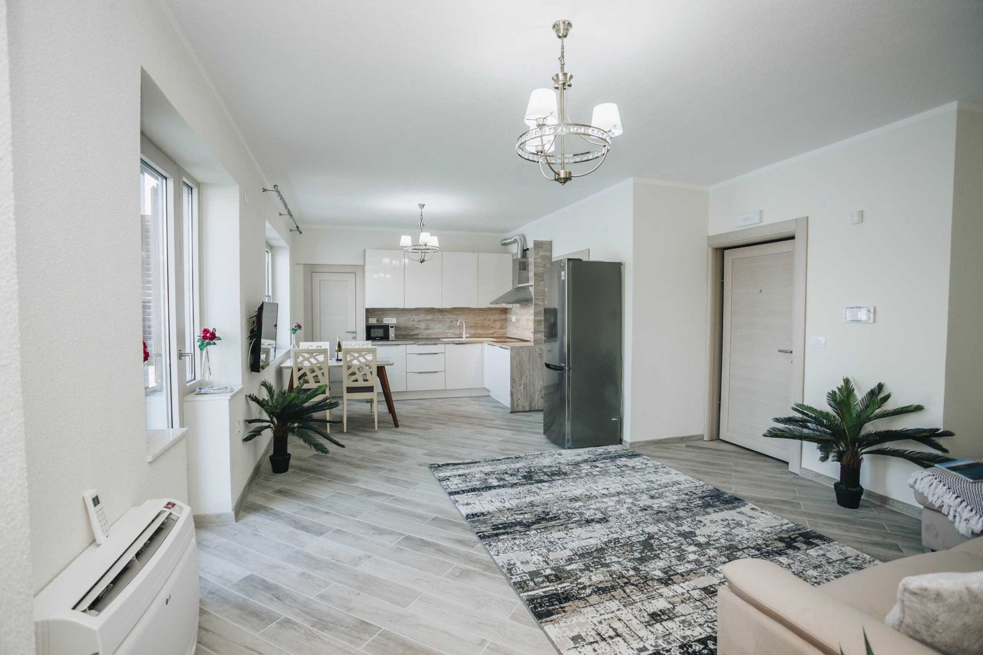 Modern living room with kitchen in a villa in Krašići, Montenegro: light furniture, tiled floor, and stylish interior.