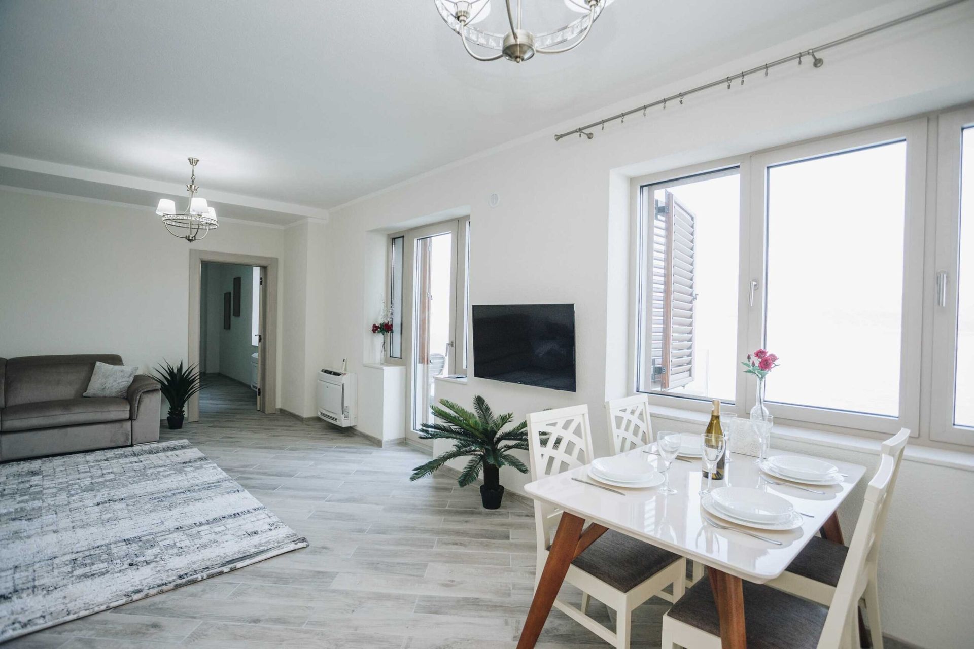 Bright living room with dining area in a villa in Krašići, Montenegro: modern furniture, panoramic windows, and decor.