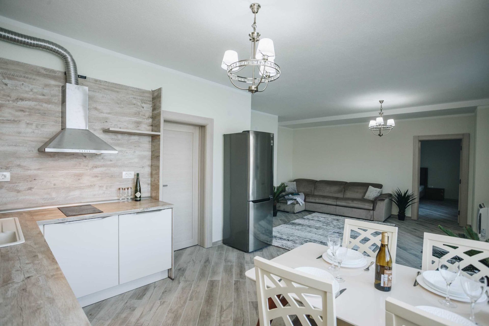 Modern kitchen-living room in a villa in Krašići, Montenegro: light-colored furniture, dining area, and a soft sofa.
