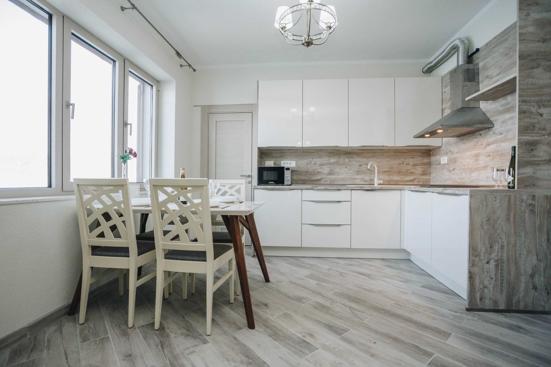 Modern kitchen with white cabinetry and dining area in a villa in Krašići, Montenegro.