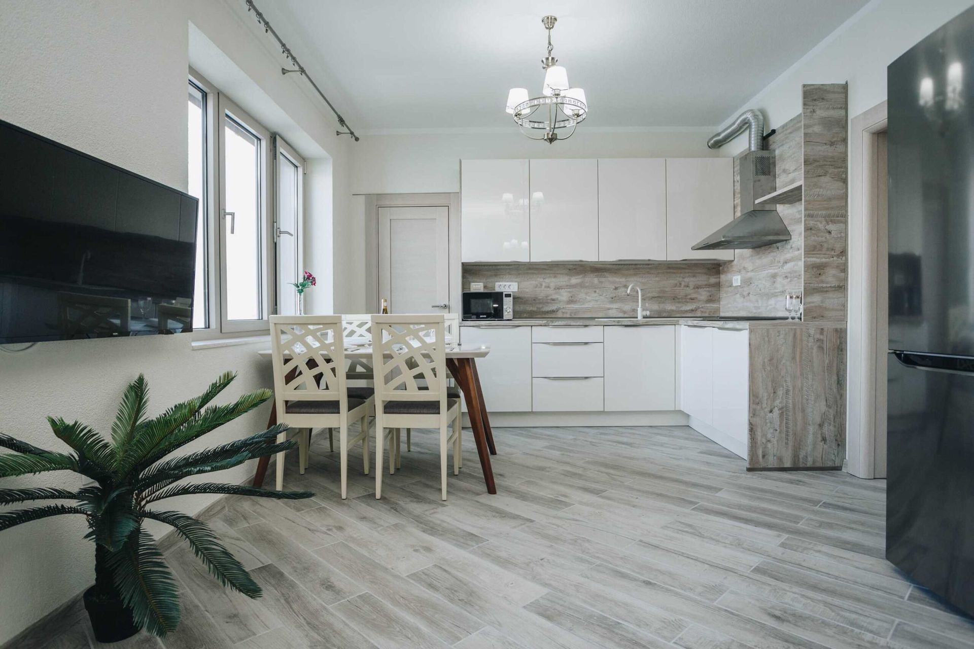 Modern kitchen-dining room with a white fitted kitchen in a villa in Krašići, Montenegro: dining area and stylish interior.