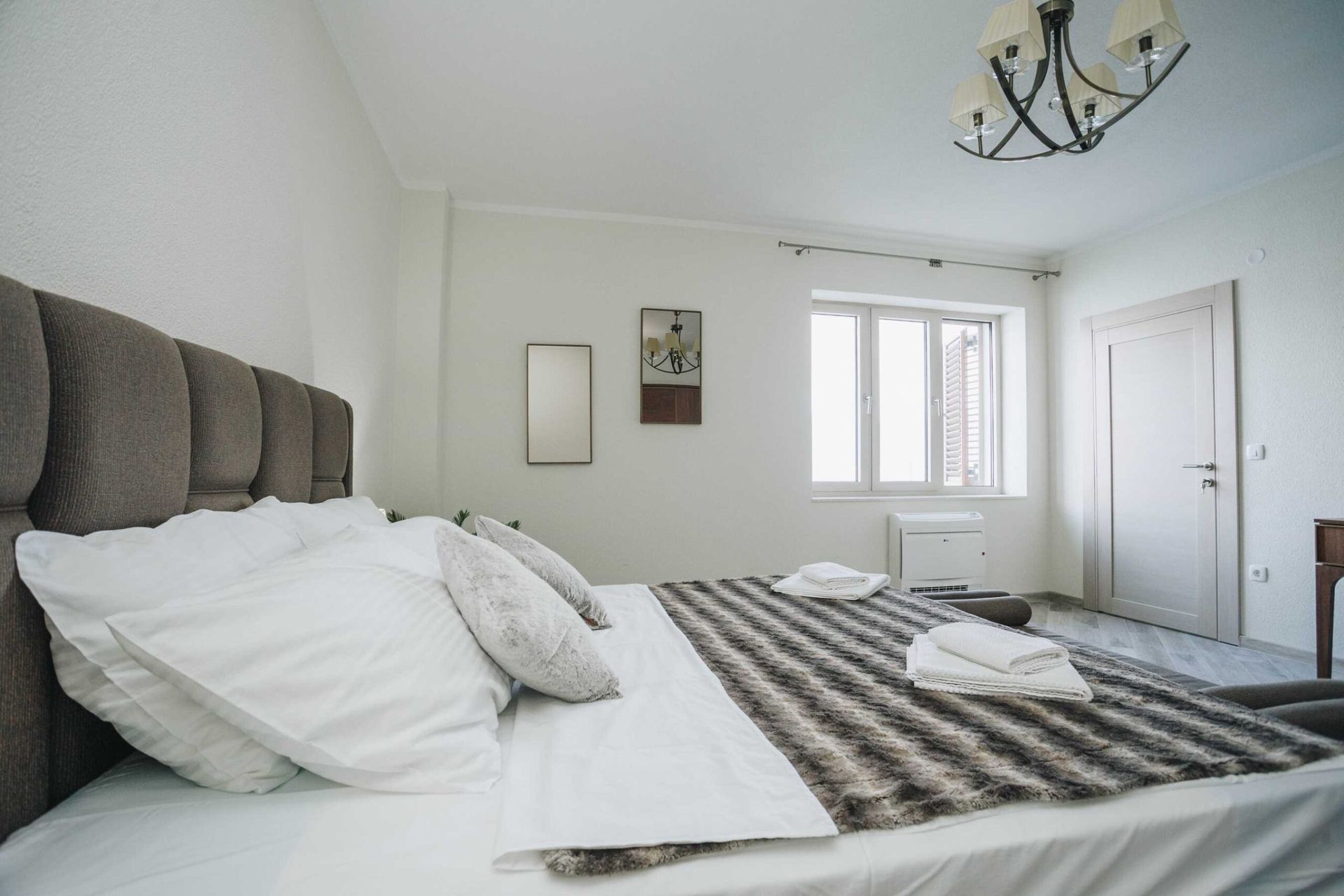 Bright bedroom with a double bed in a villa in Krašići, Montenegro: modern interior, upholstered headboard.