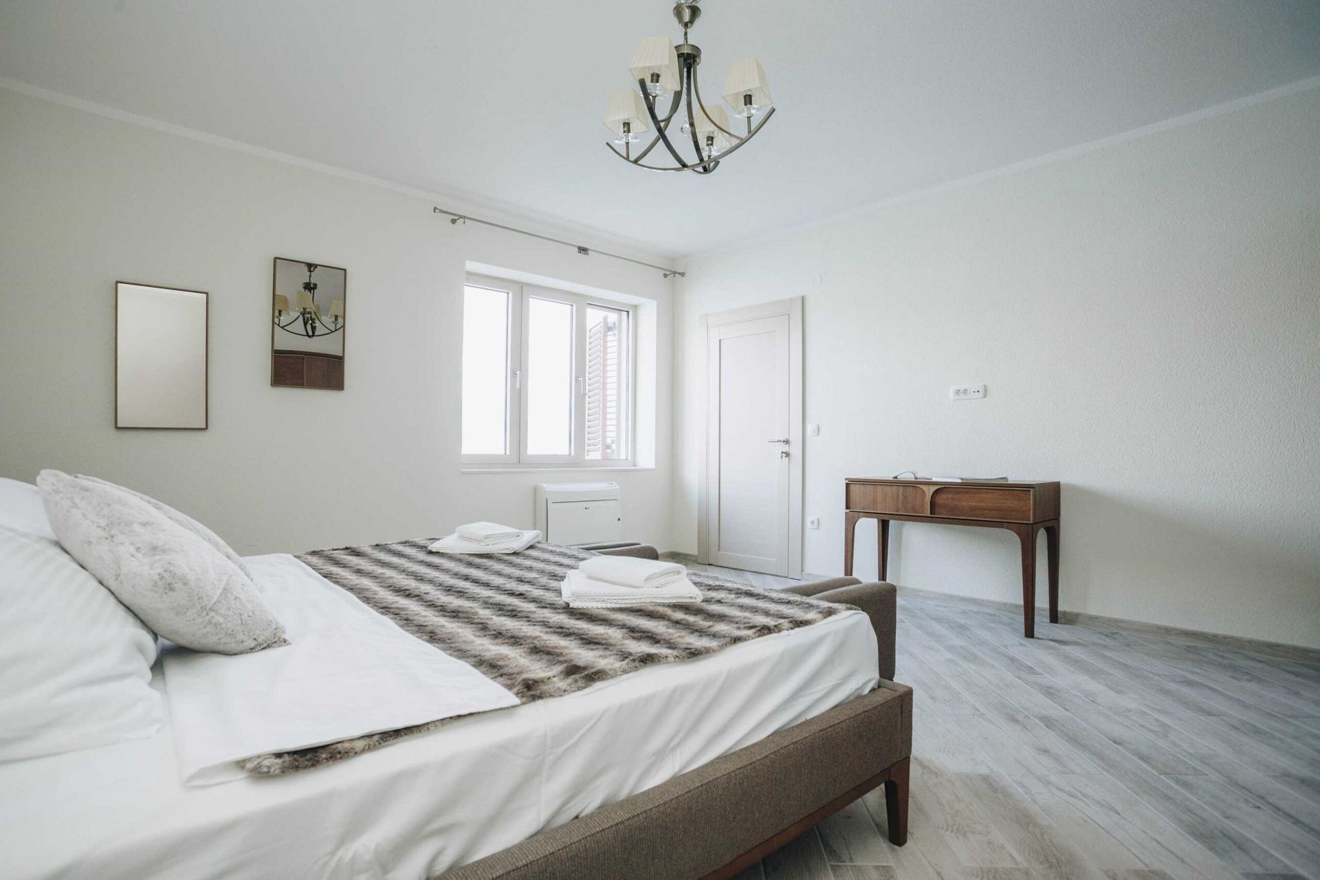 Bright bedroom with a double bed and a vintage desk in a villa in Krašići, Montenegro.