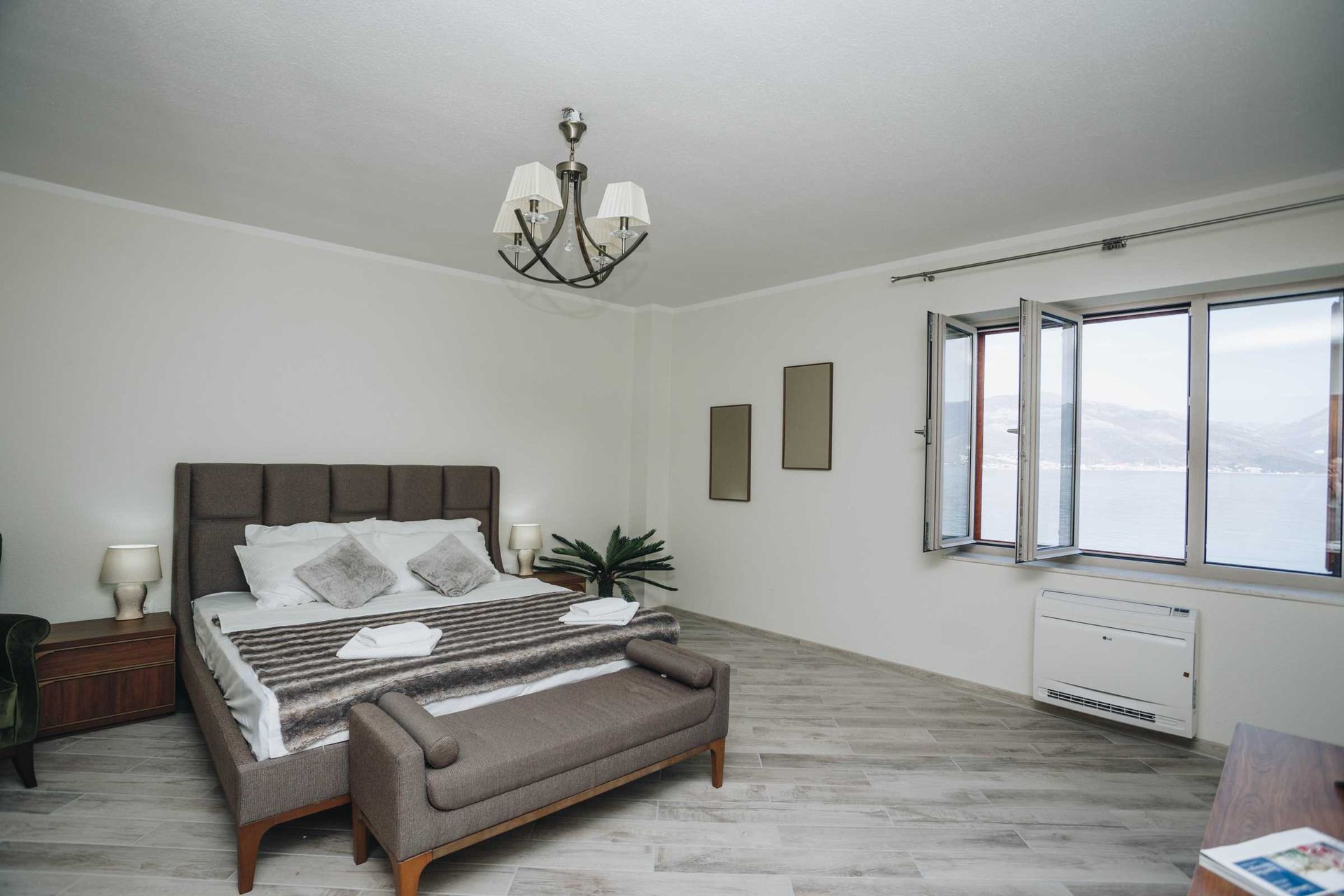 Bedroom in a villa in Krašići, Montenegro: double bed, sea view from the window, modern finishes and furniture.