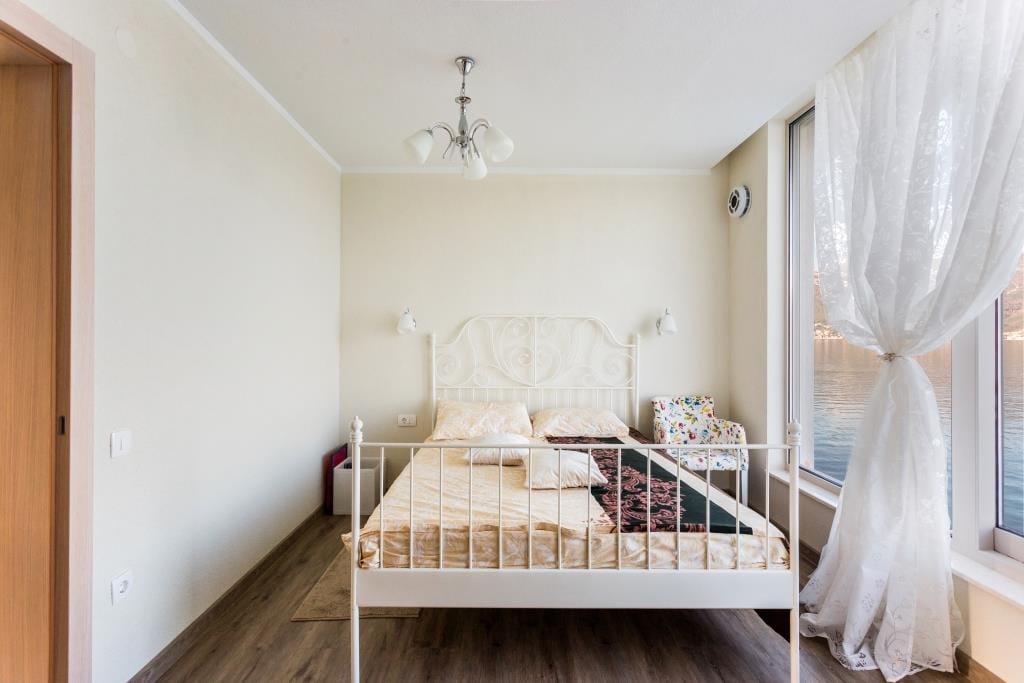 Bright bedroom with a double bed and panoramic sea view in a villa, Krašići, Montenegro.
