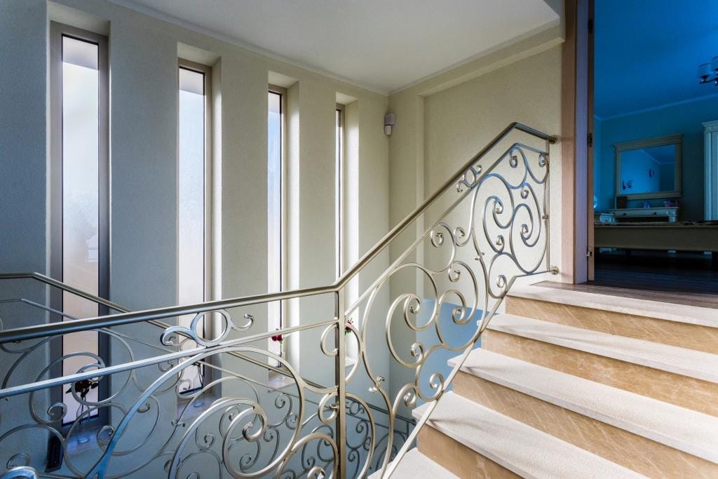 Staircase with wrought-iron railings and marble steps in the interior of a villa in Krašići, Montenegro.