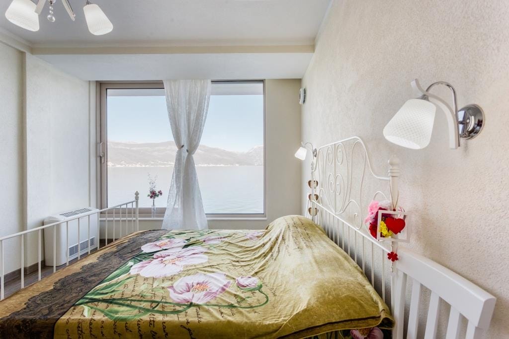 Bedroom with a double bed and panoramic sea view in a villa, Krašići, Montenegro.