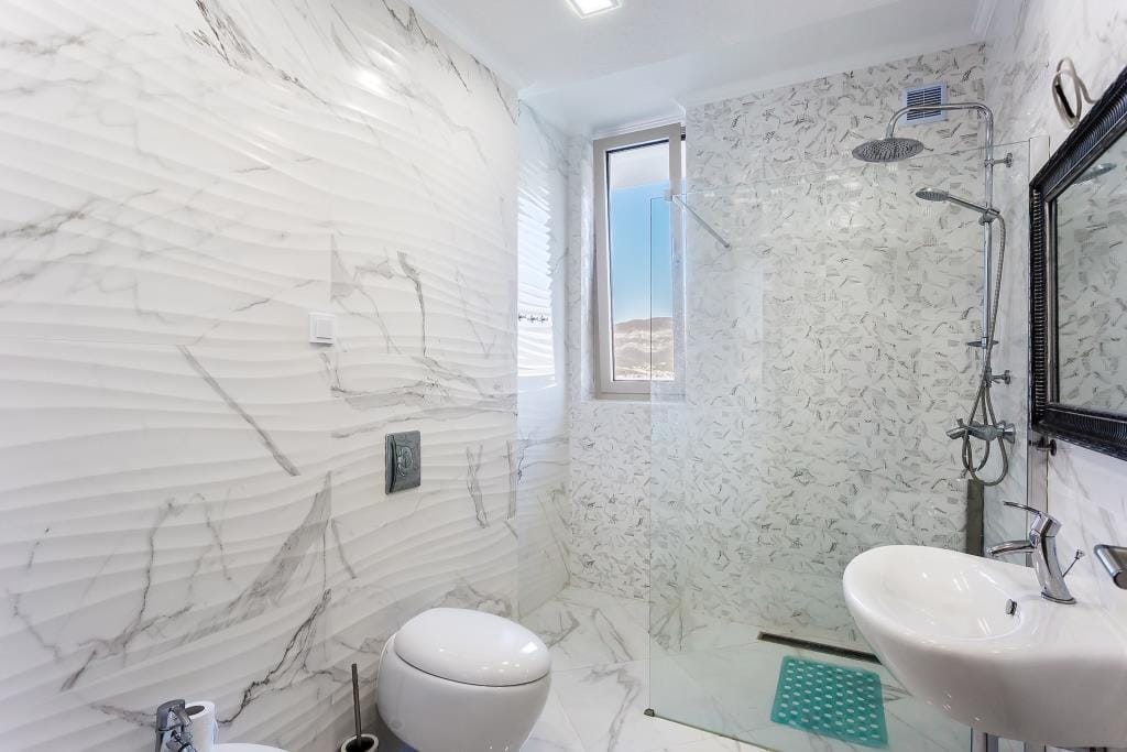 Modern bathroom with marble-style finishes and a shower cabin in a villa in Krašići, Montenegro.