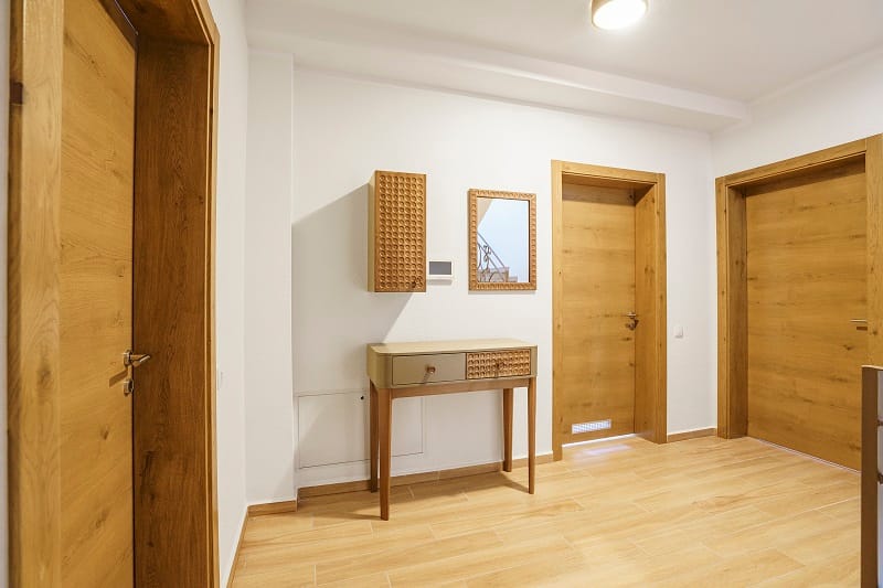Bright villa hallway in Krašići, Montenegro: wooden interior doors, a console table, and a mirror in the interior.