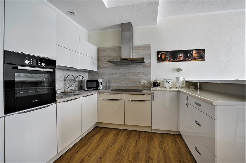 Modern kitchen with white cabinets and Bosch appliances in a villa in Krašići, Montenegro.