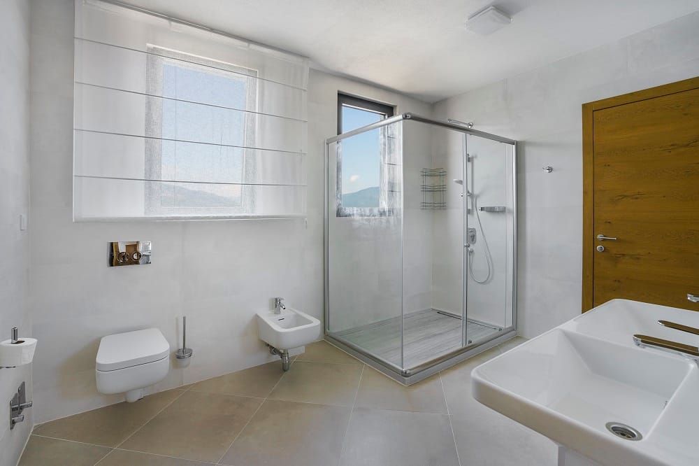 Modern bathroom with a shower cabin in a villa in Krašići, Montenegro: light tiles, fixtures, and mountain views.