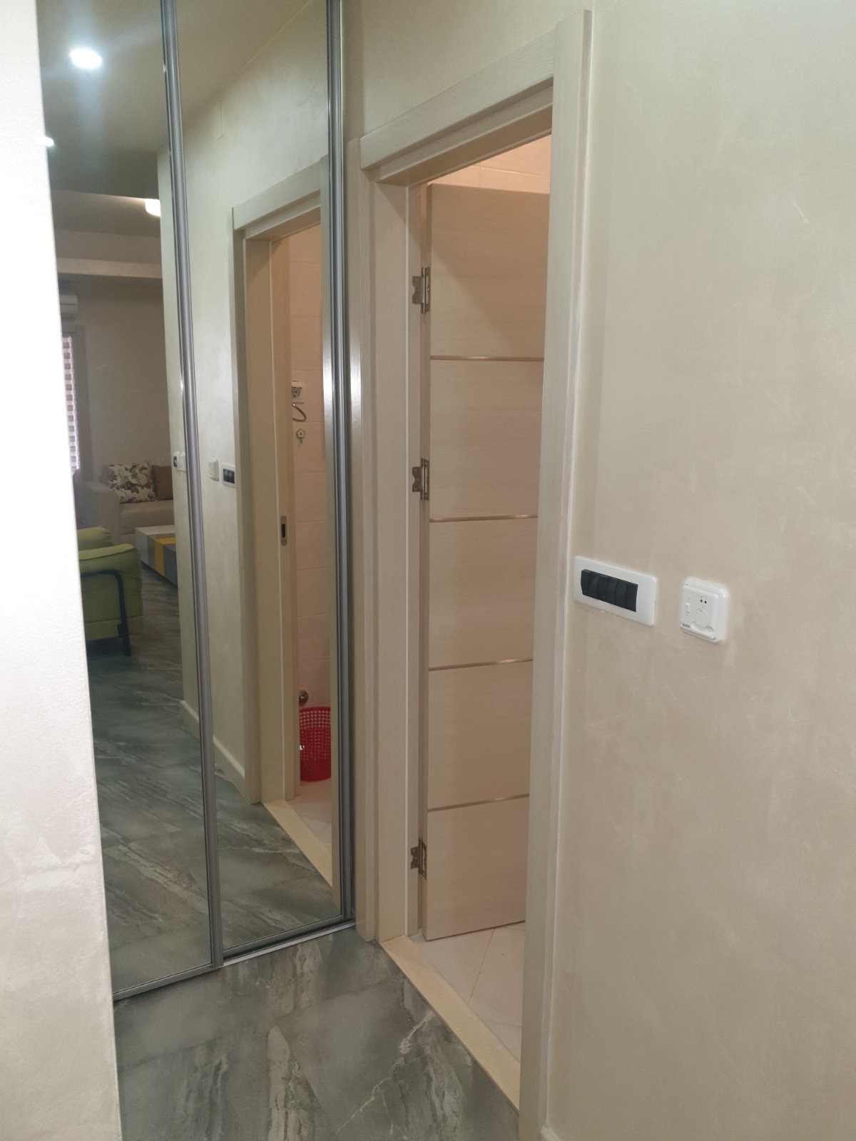 Hallway with a mirrored sliding wardrobe and light interior doors in an apartment, Budva, Montenegro.