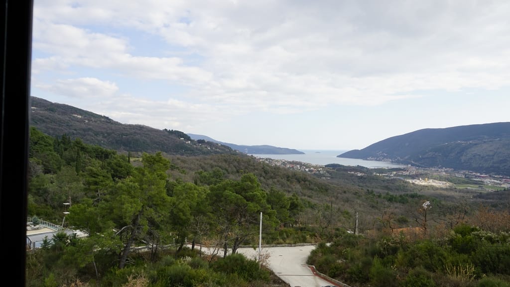 Panoramic view of the sea and mountains from a villa in Igalo, Herceg Novi, Montenegro: green hills and a sea bay.