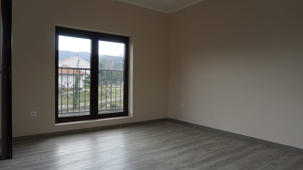 Bright living room with laminate flooring and a panoramic window in a villa in Igalo, Herceg Novi, Montenegro.